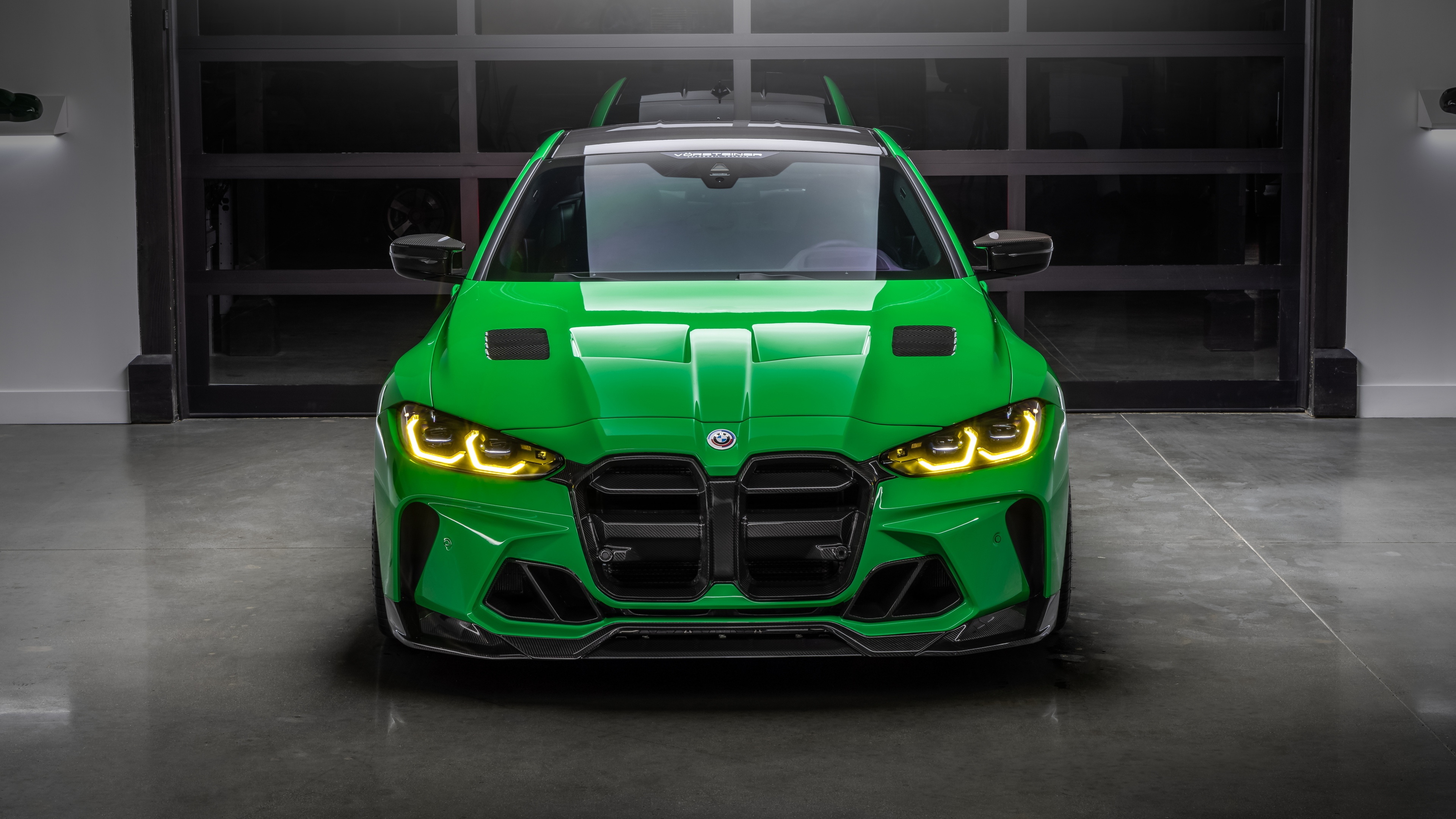 A high-resolution, close-up shot of a modern, aerodynamic green sports car with premium Vorsteiner-style design features.