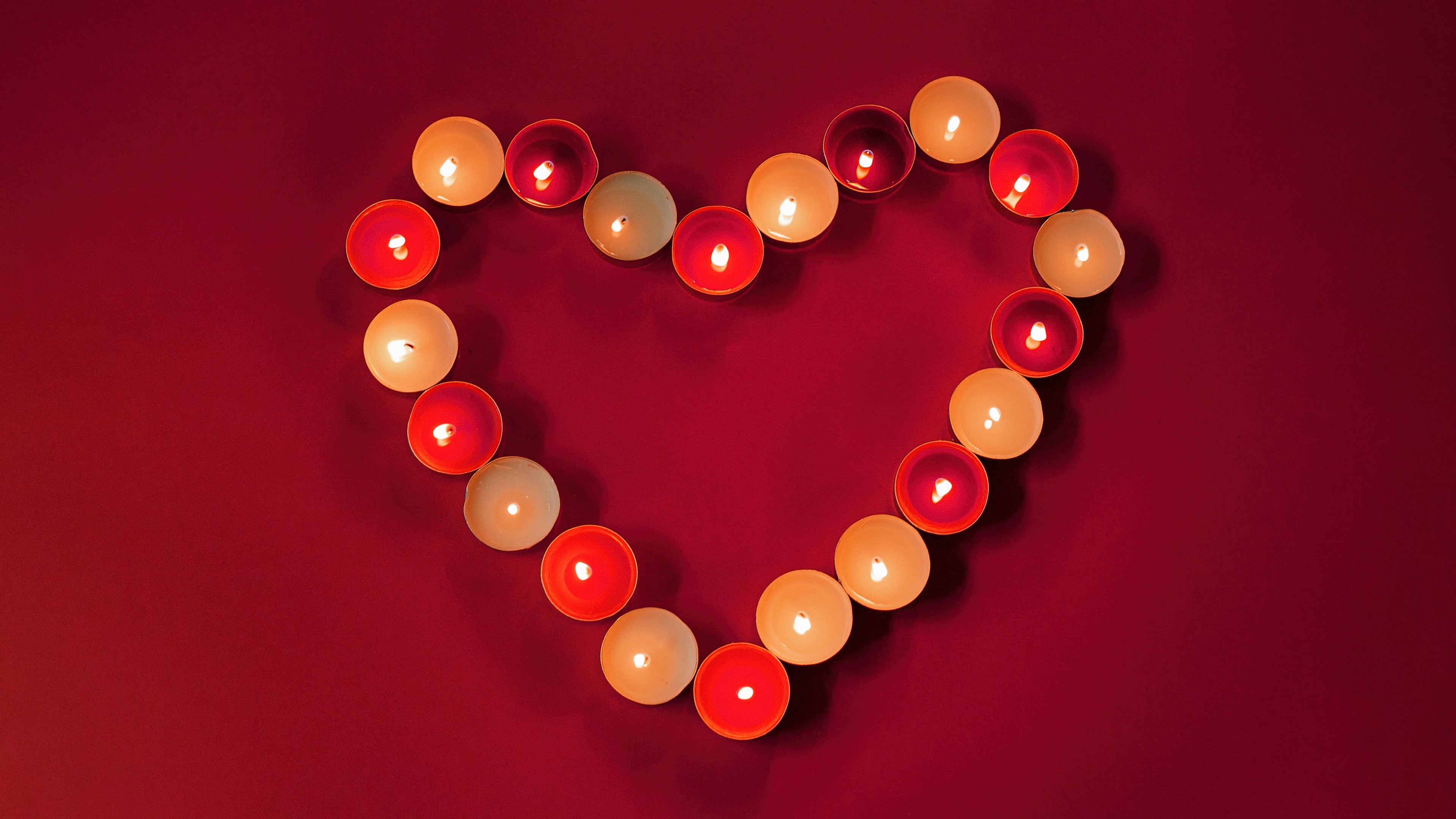 A deep red heart shape centered on a dark crimson aesthetic background.