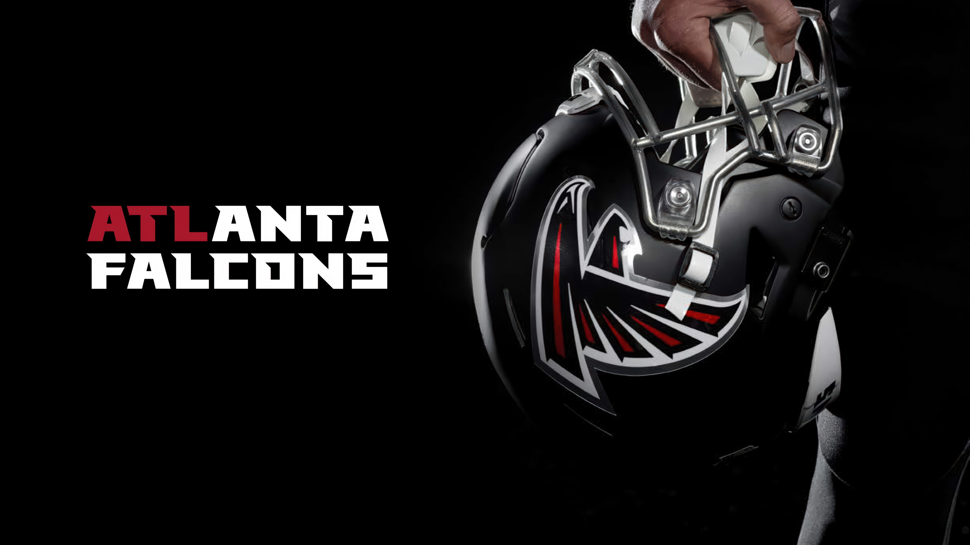 Close-up of an Atlanta Falcons football helmet on a dark background.