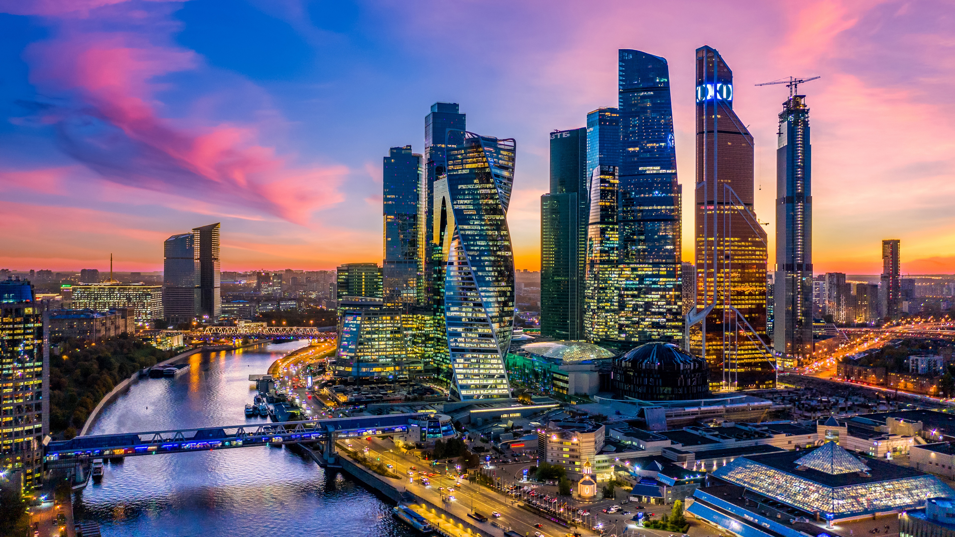 A panoramic view of Moscow skyscrapers and city lights during the evening.