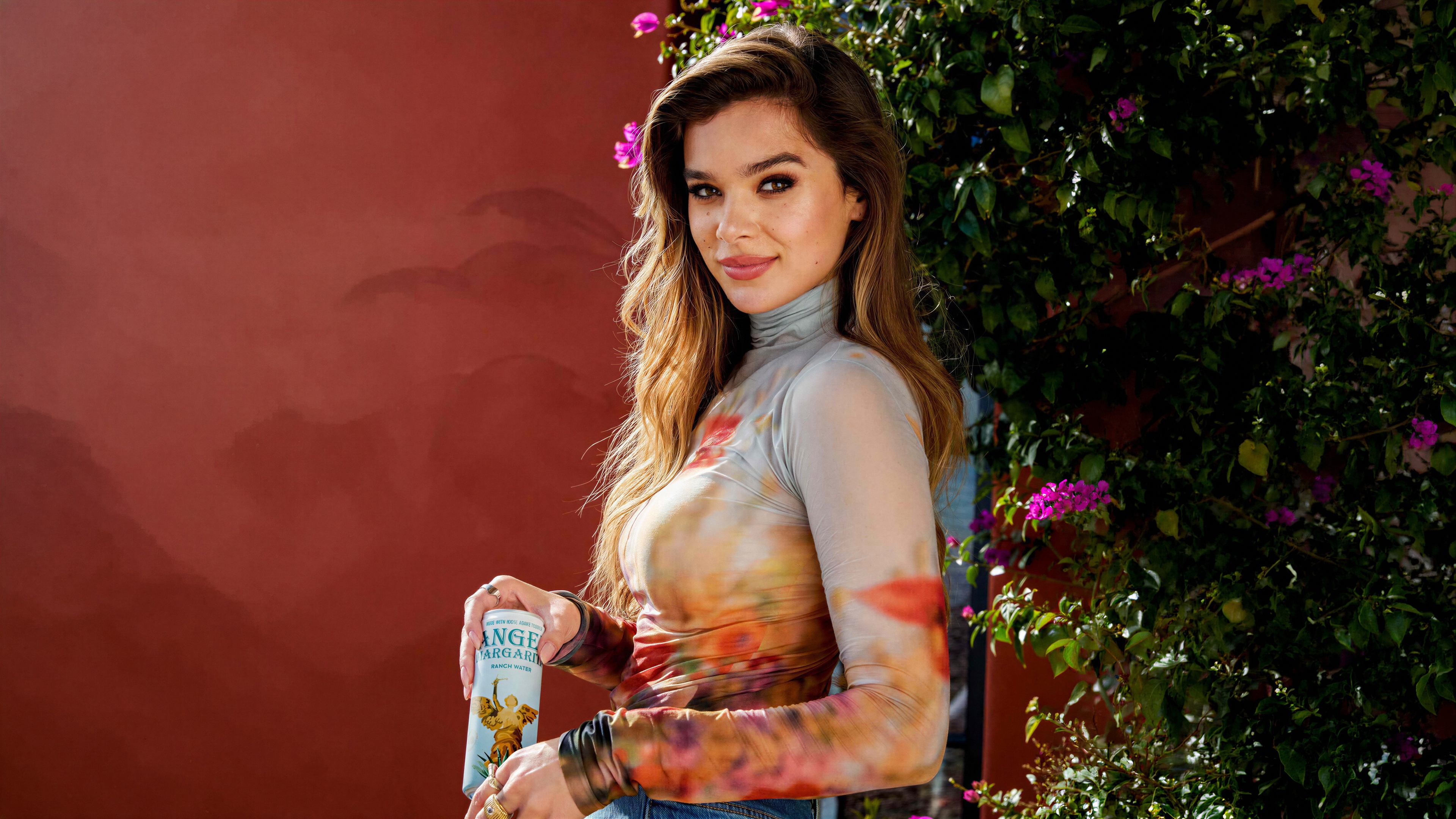 A beautiful high-resolution portrait of actress Hailee Steinfeld posing elegantly with a cocktail.