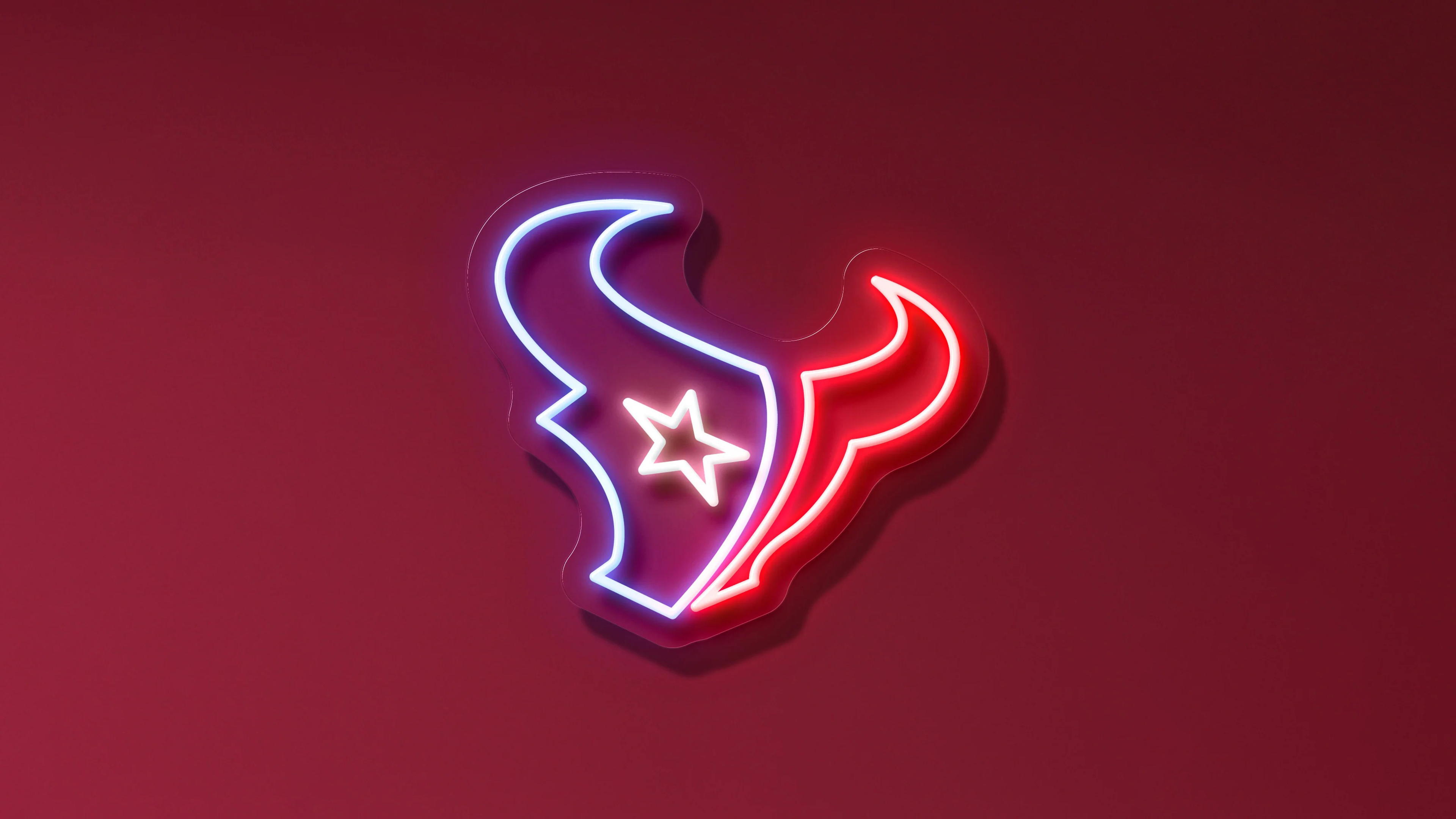 Glowing neon Houston Texans NFL logo on a red background.
