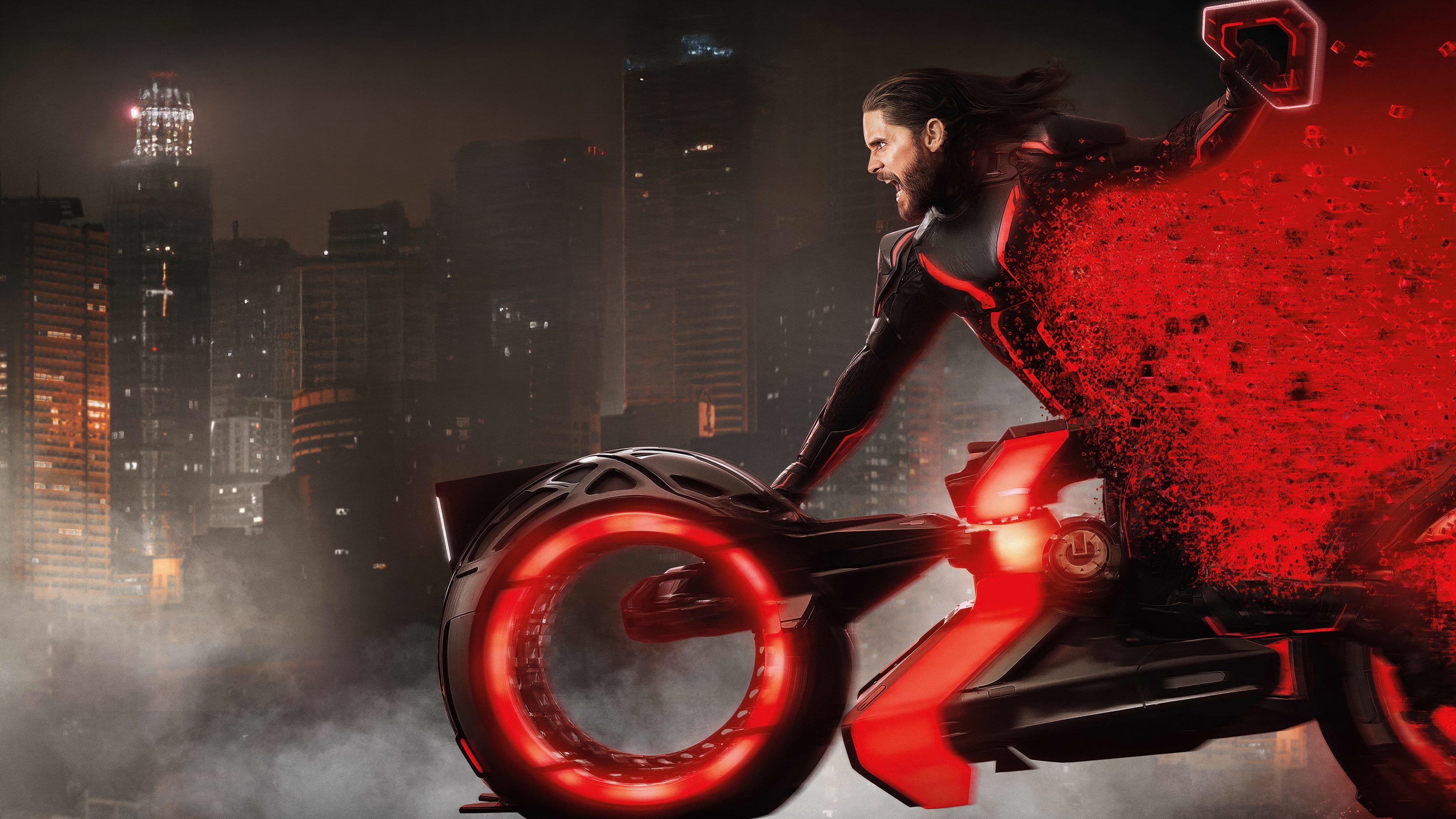 Jared Leto riding a neon-lit Light Cycle in the digital landscape of Tron: Ares