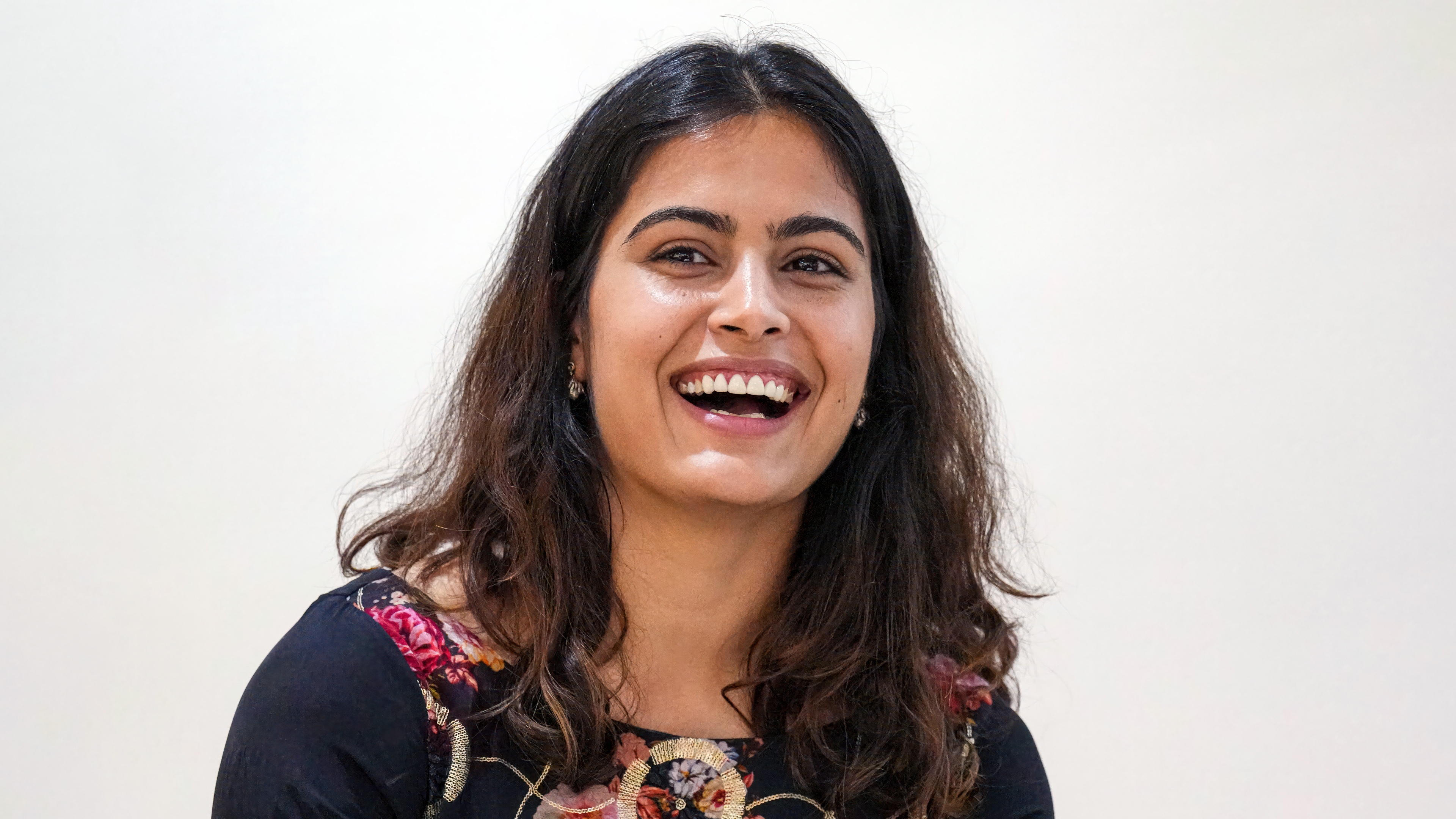 A high-resolution portrait of Indian athlete Manu Bhaker smiling against a white background.