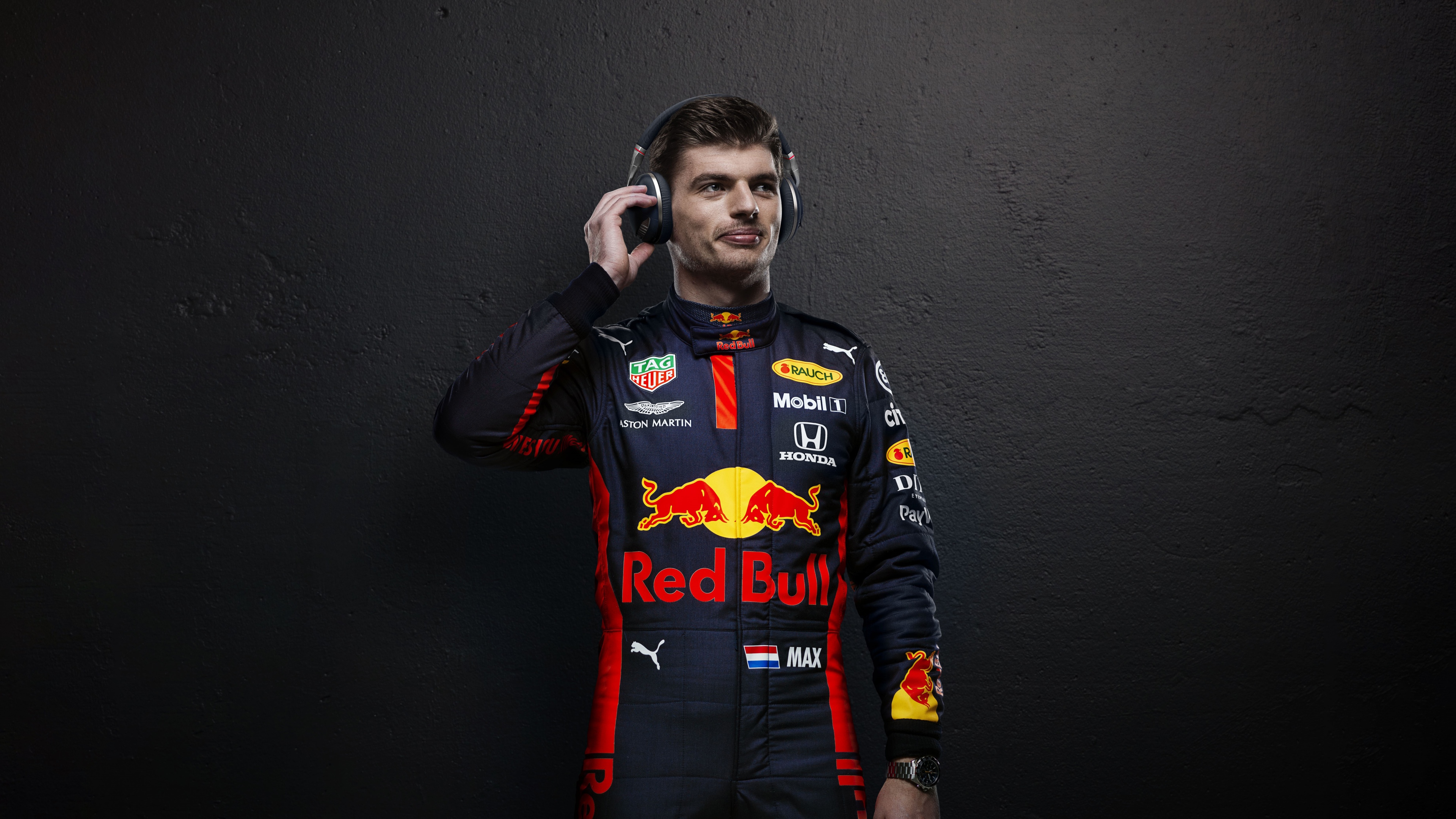 Cinematic portrait of Max Verstappen in Red Bull Racing Formula One gear against a dark background