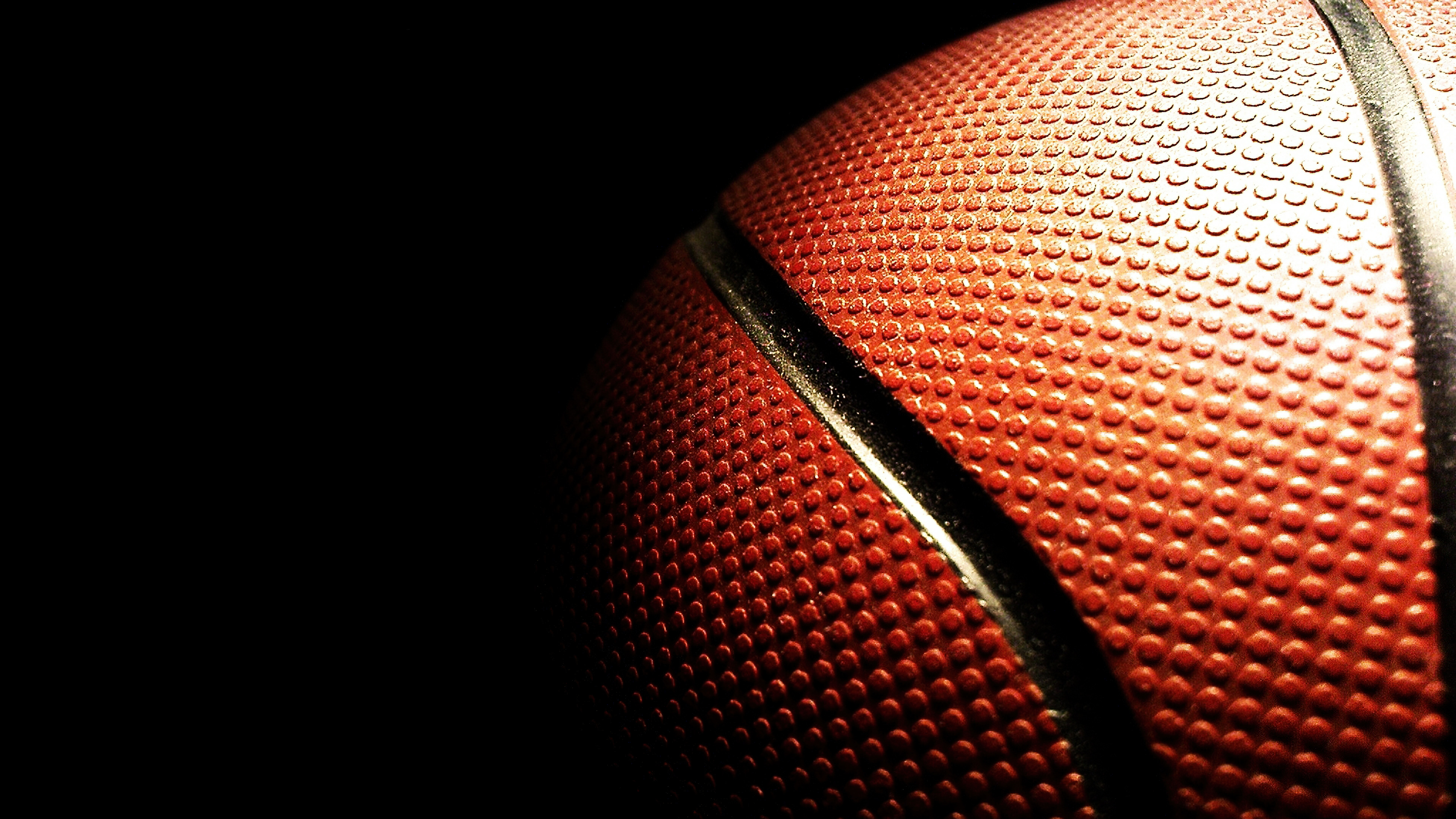 Close-up of a textured basketball on a black background