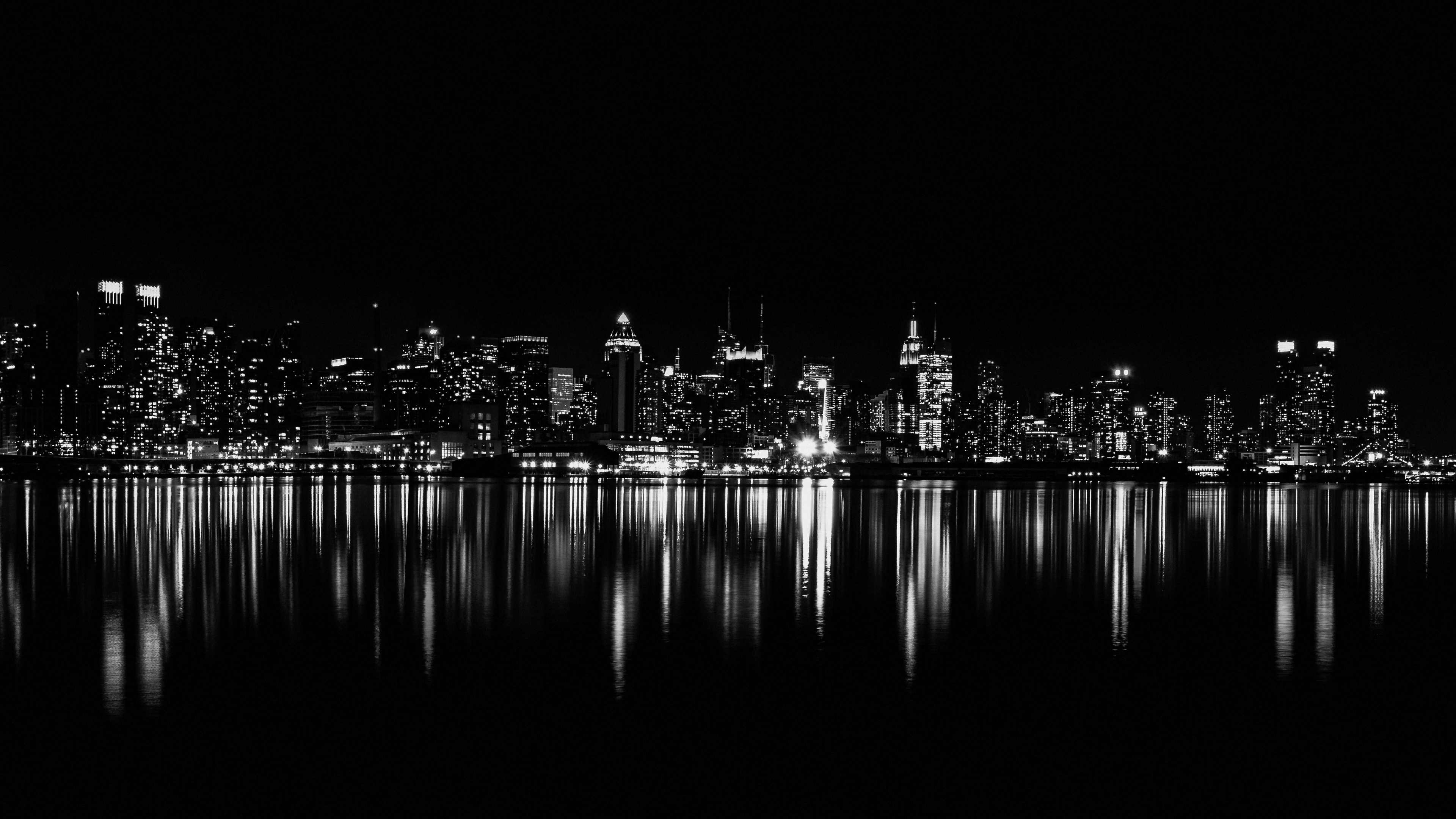 A cinematic night view of New York City streets featuring dark aesthetics and glowing light reflections.