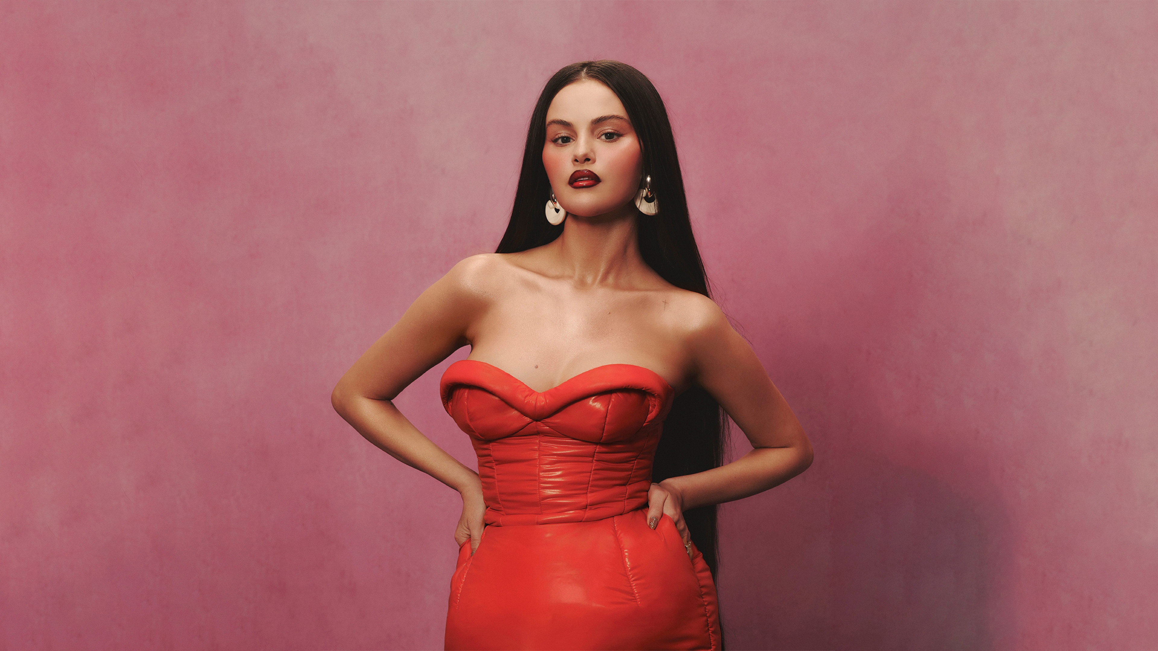 A high-resolution portrait of Selena Gomez featuring a pastel red aesthetic and elegant, soft lighting.