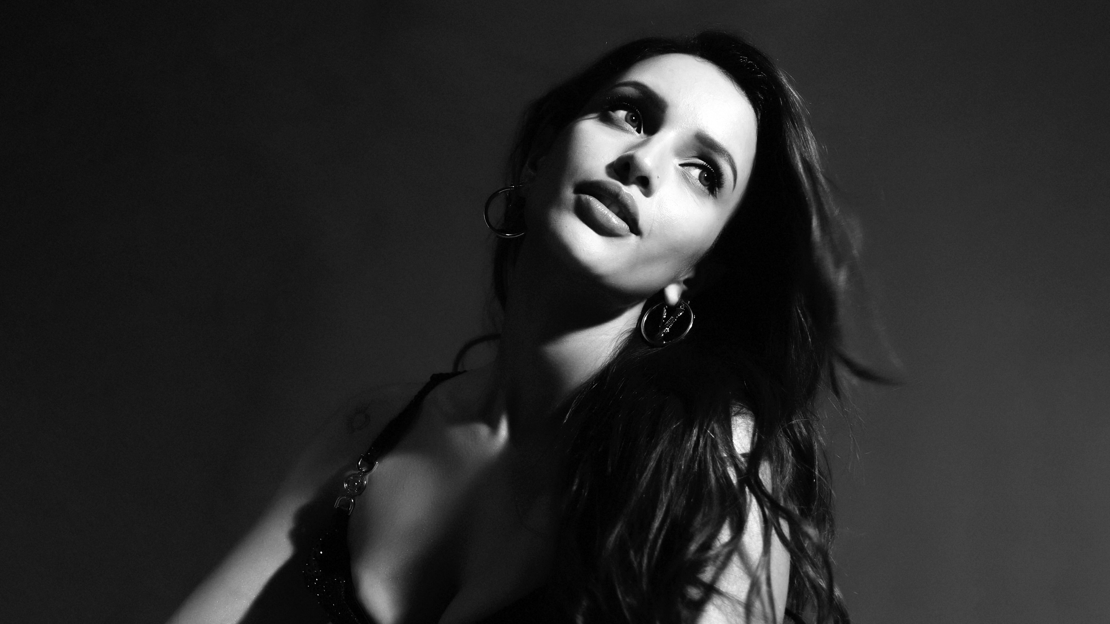 A high-contrast black and white portrait of Indian actress Tripti Dimri against a dark, moody background.