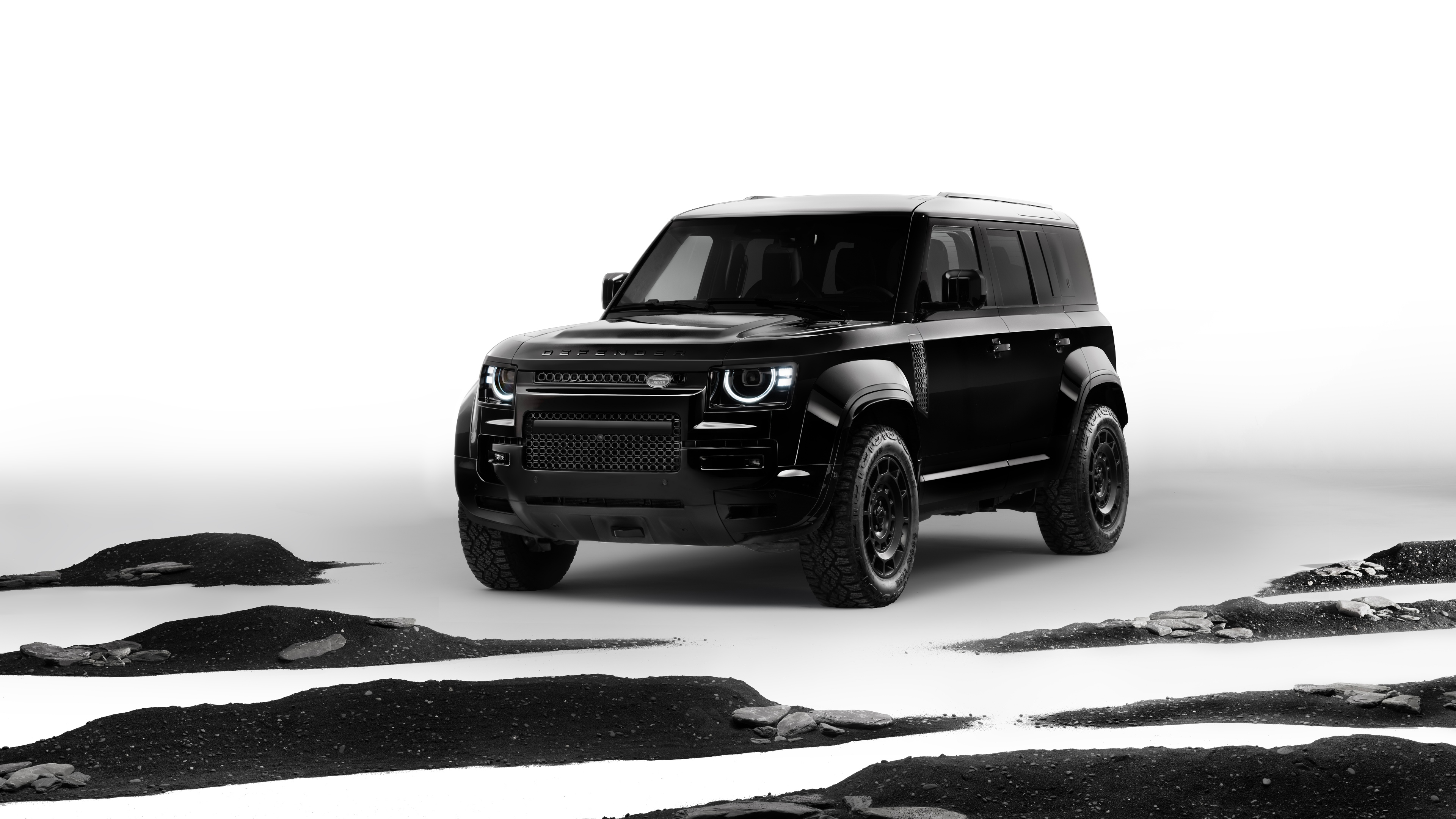 A high-resolution black and white professional photograph of the 2025 Land Rover Defender OCTA Black Edition SUV.