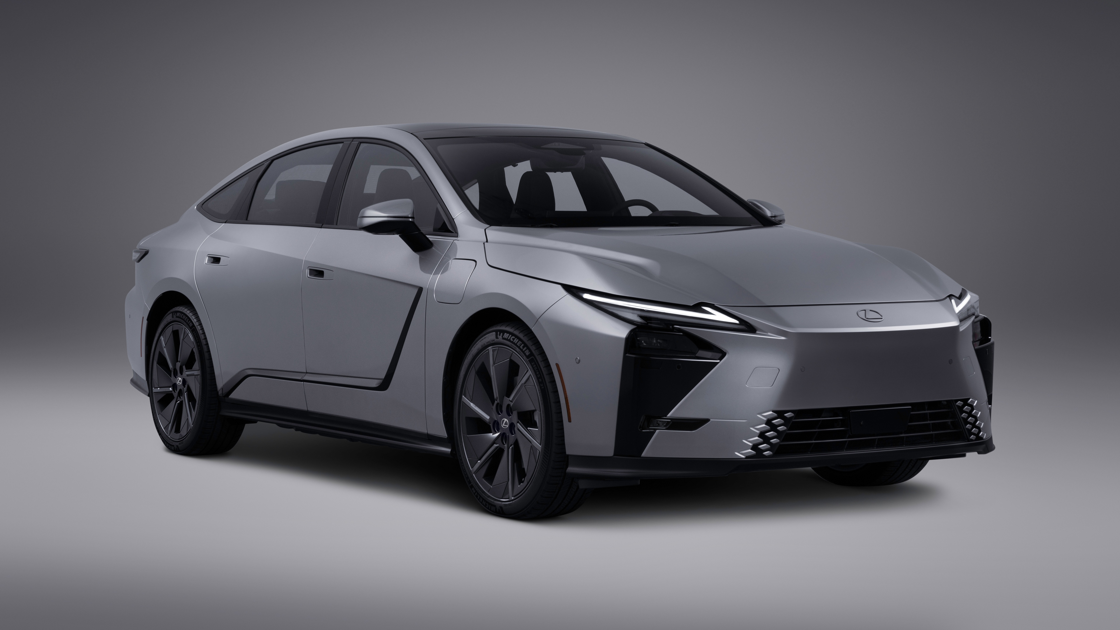 Sleek and futuristic luxury electric vehicles with aerodynamic curves and advanced LED lighting in a high-tech setting.