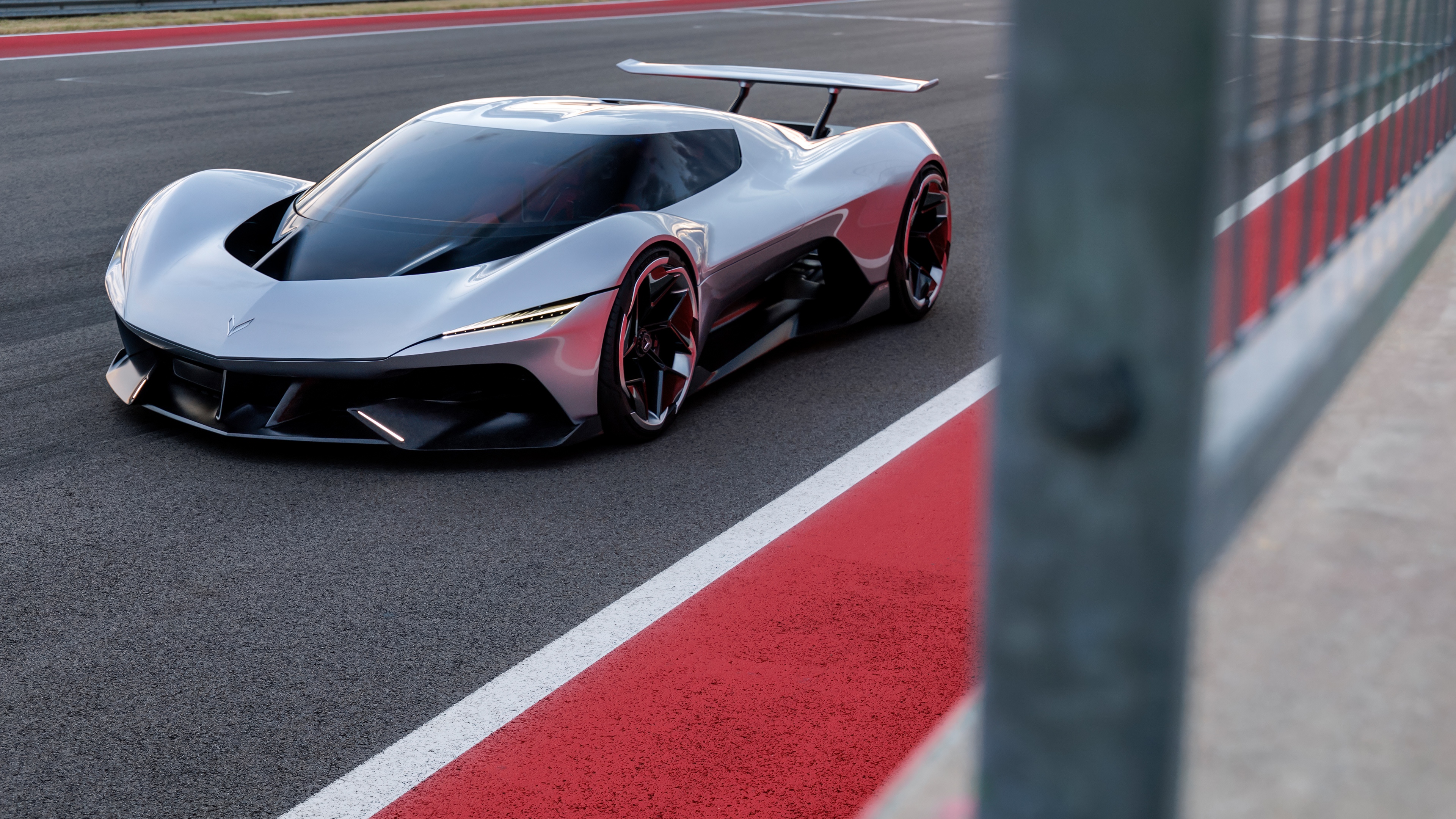 Futuristic Chevrolet Corvette CX Vision Gran Turismo concept car racing on a professional circuit track.