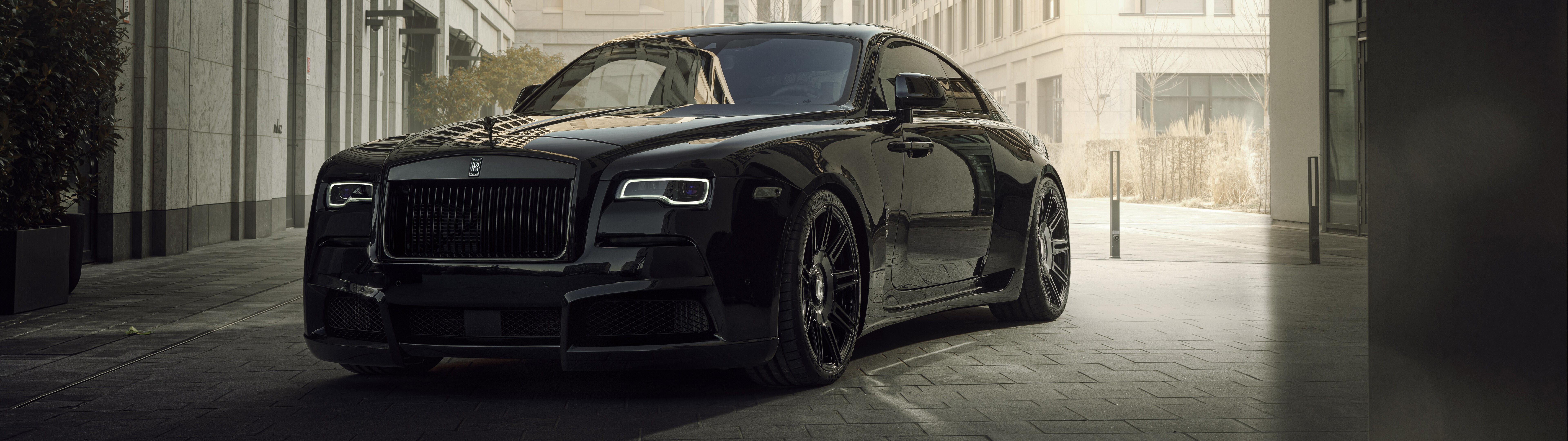 Una veduta ravvicinata di una lussuosa Rolls-Royce Wraith nera, parcheggiata in un ambiente elegante.