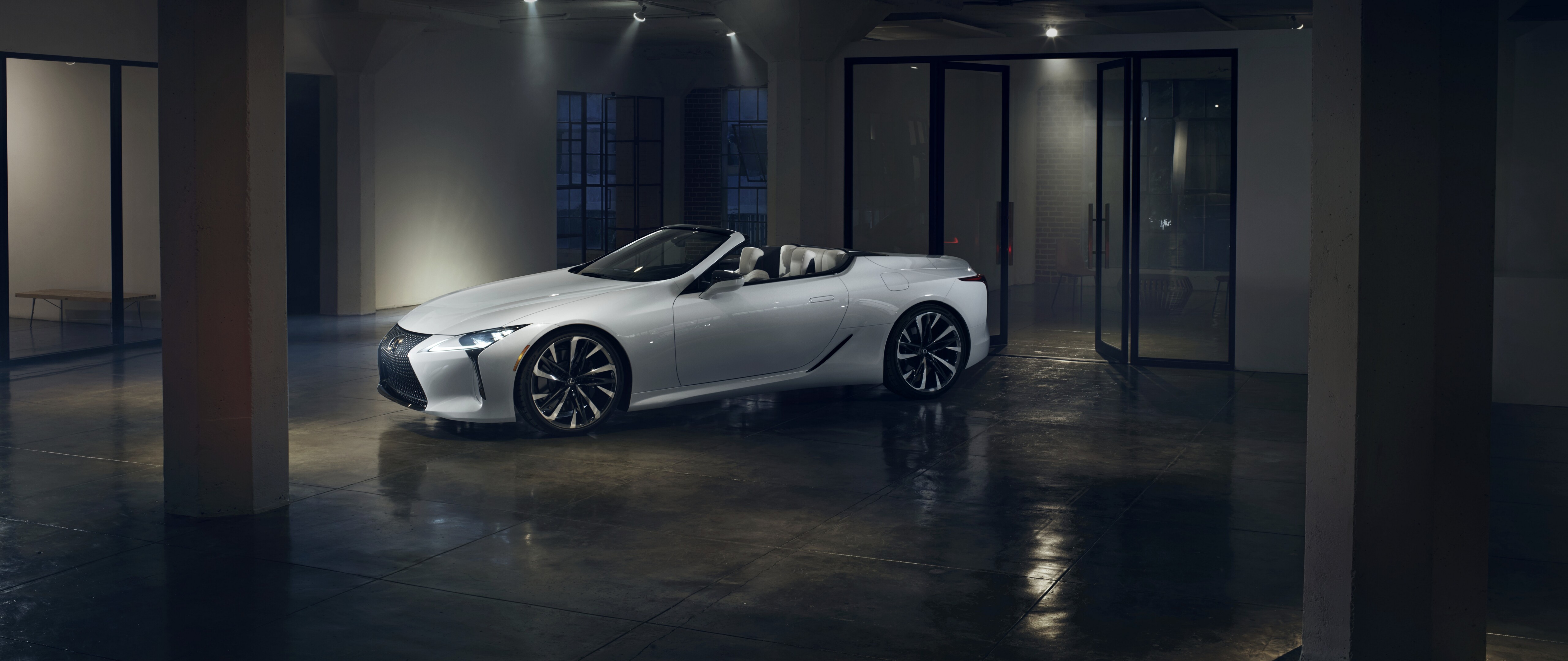 A sleek white Lexus LC 500 supercar captured in a high-quality automotive shot showing its luxury grand tourer profile.