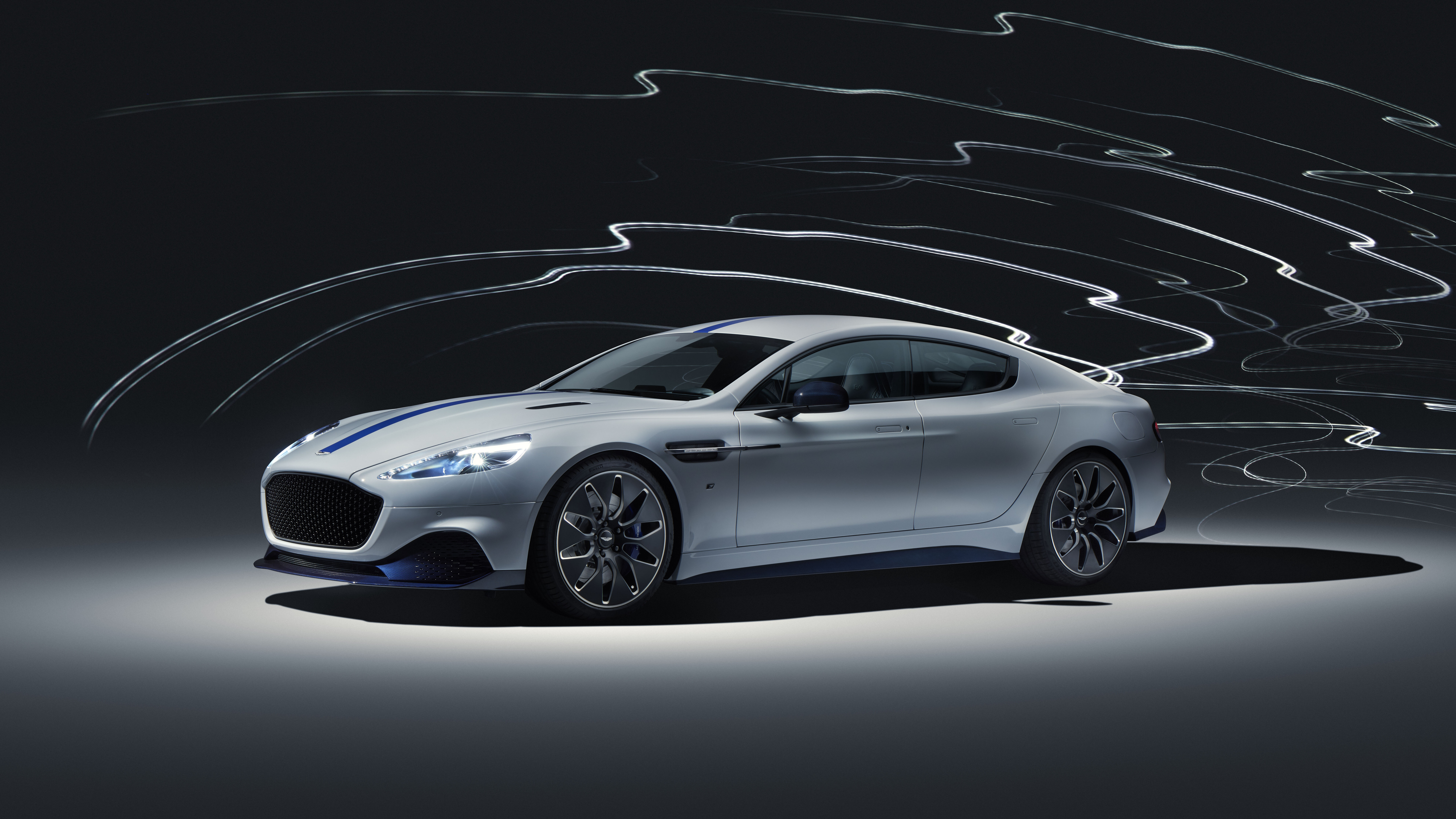 Un’elegante Aston Martin Rapide E, un’auto di lusso elettrica di colore argento.