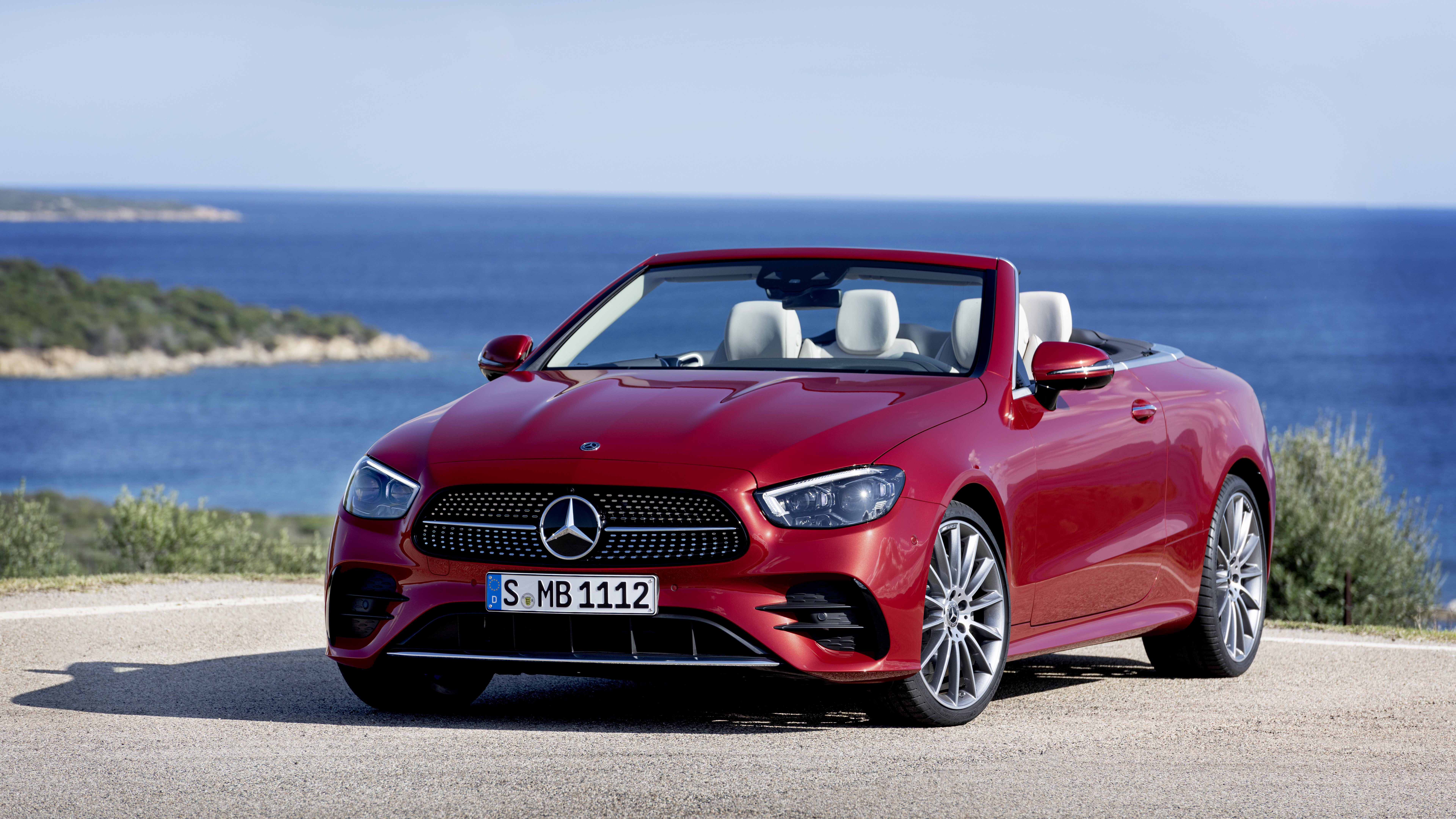 Un’elegante Mercedes-Benz E 450 Cabriolet, un’auto scoperta di lusso, ambientata in un contesto professionale.