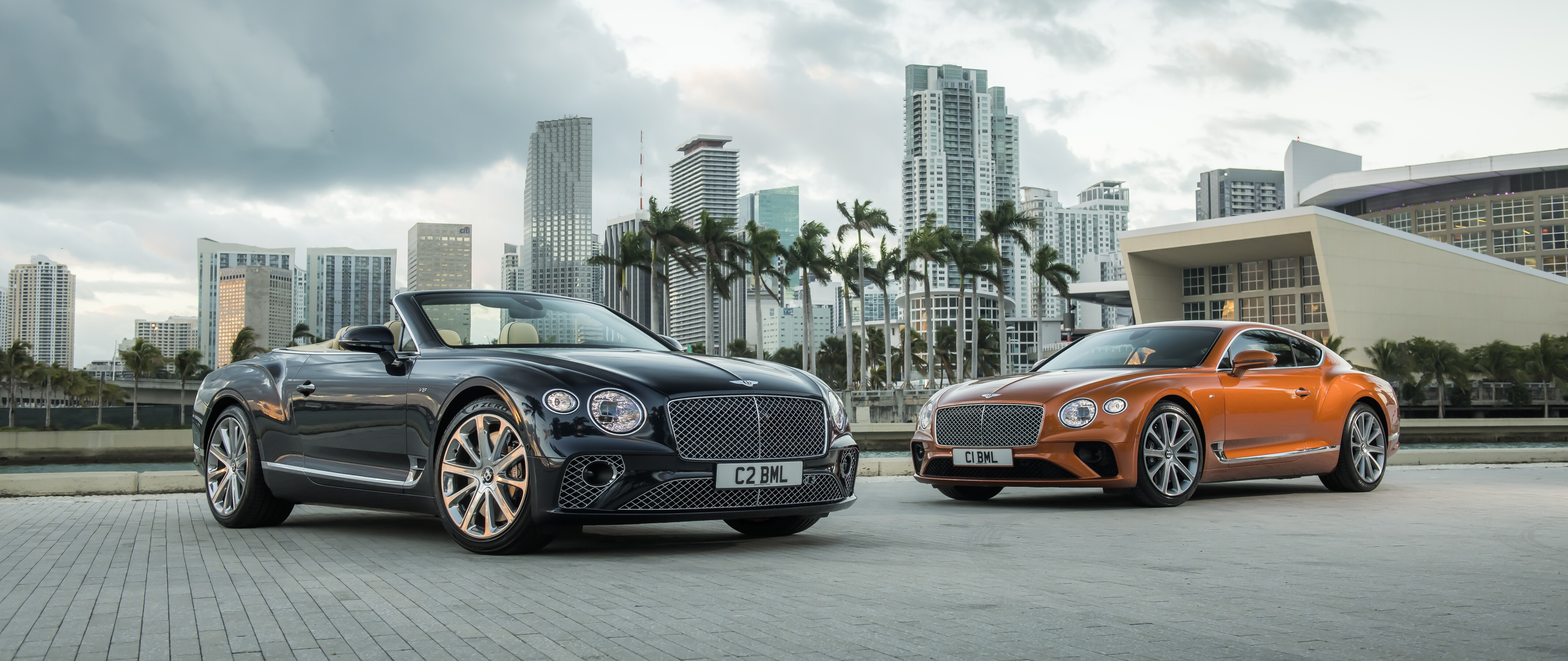 A luxury Bentley Continental GT convertible featuring a sleek black body with striking orange details.
