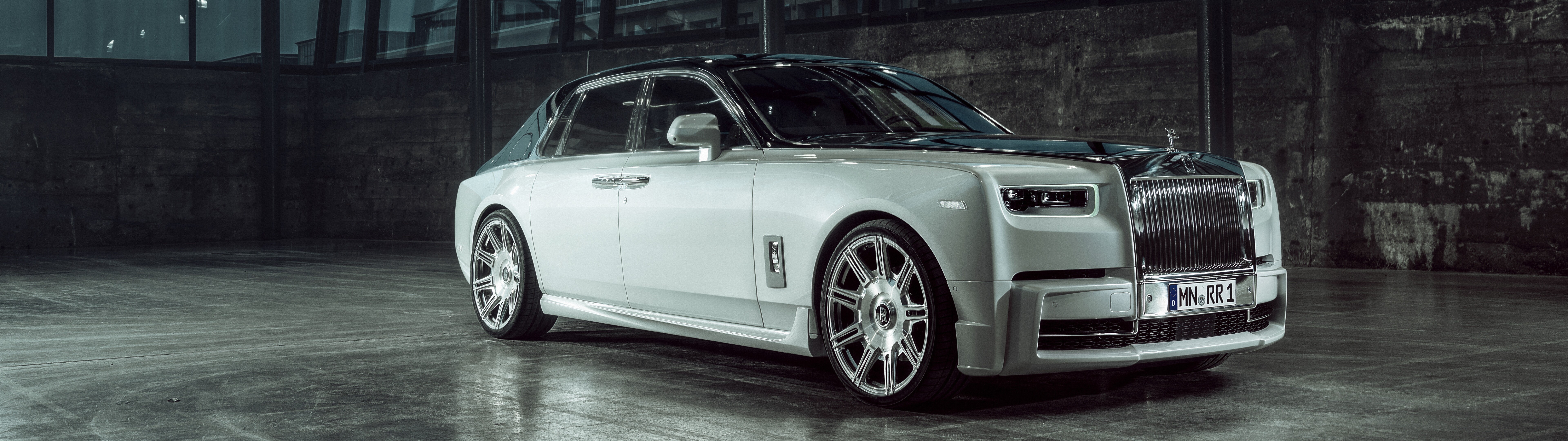 Una vista mozzafiato di una Rolls-Royce Phantom, un’elegante berlina di lusso, che mette in risalto la sua iconica calandra e la sua raffinata linea.