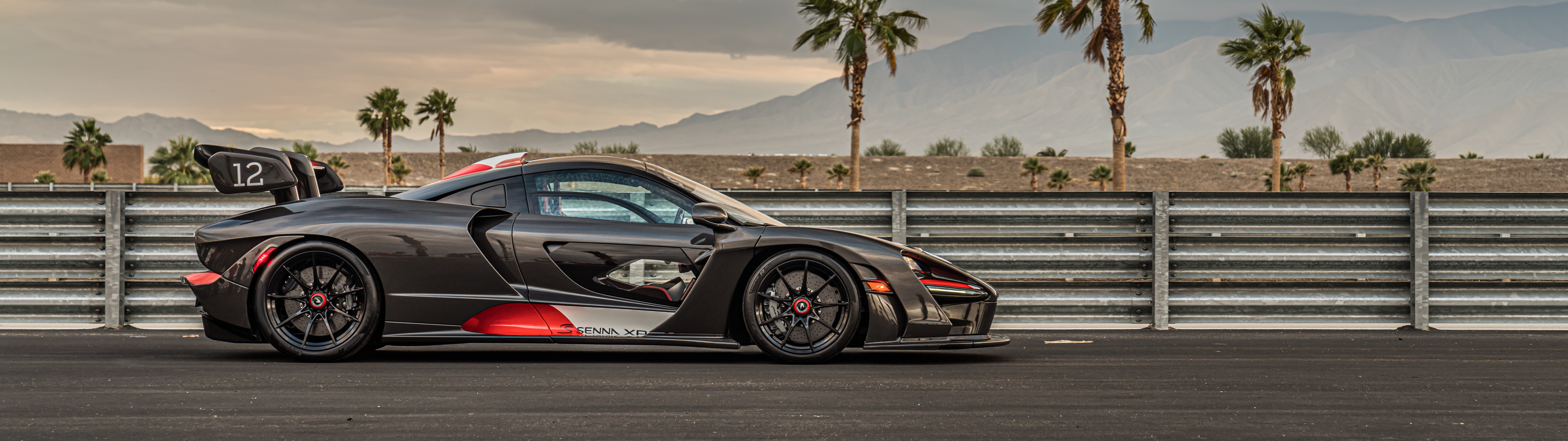 Una vista dettagliata della McLaren Senna, un’auto sportiva di lusso, che ne mette in risalto la carrozzeria aerodinamica e gli elementi di design aggressivi.