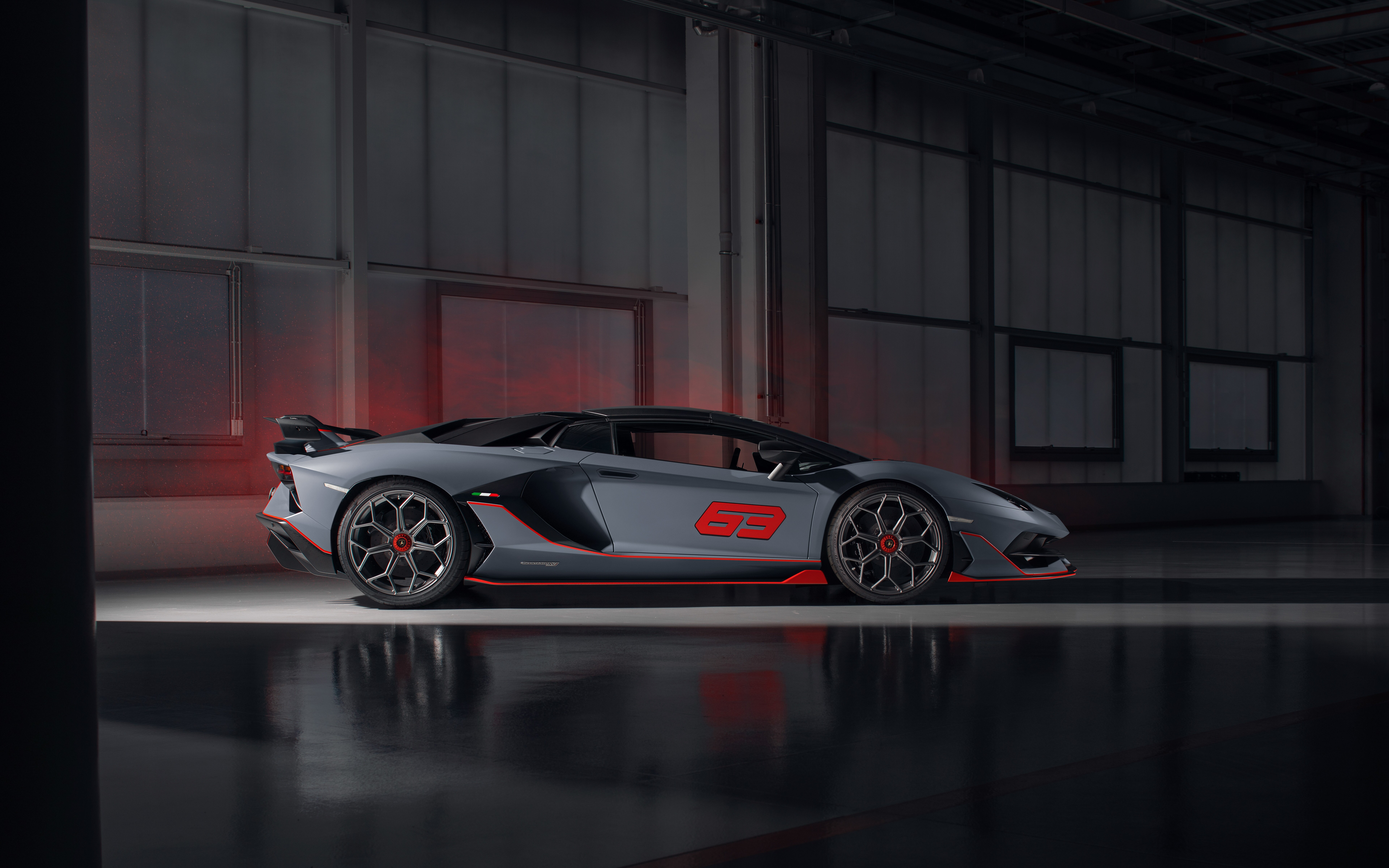 A sleek, metallic silver Lamborghini Aventador SVJ supercar showcasing its aerodynamic design.