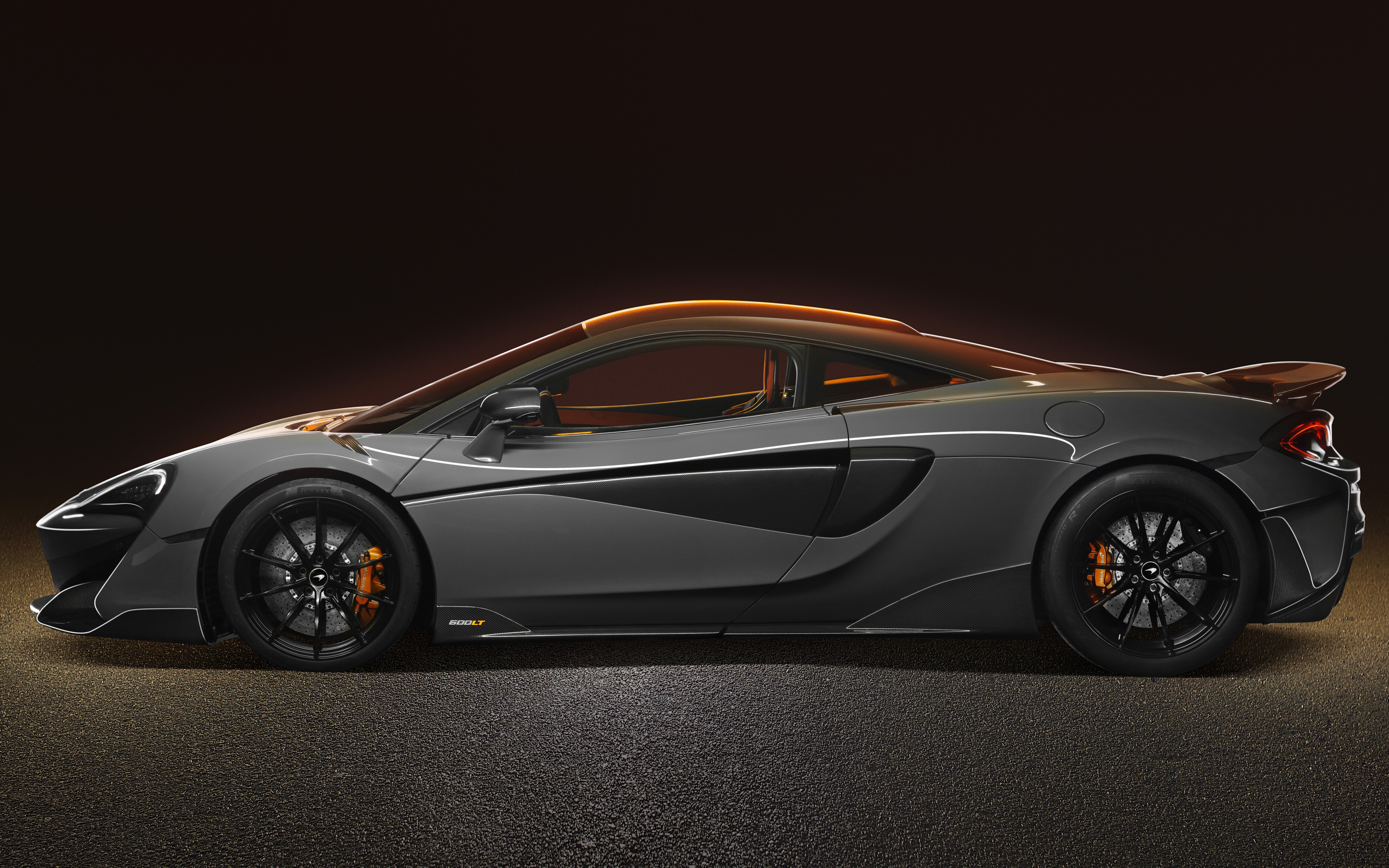 Una vista ad alta risoluzione di una supercar McLaren 600LT color argento, che ne mette in risalto la carrozzeria aerodinamica e la vernice metallizzata.