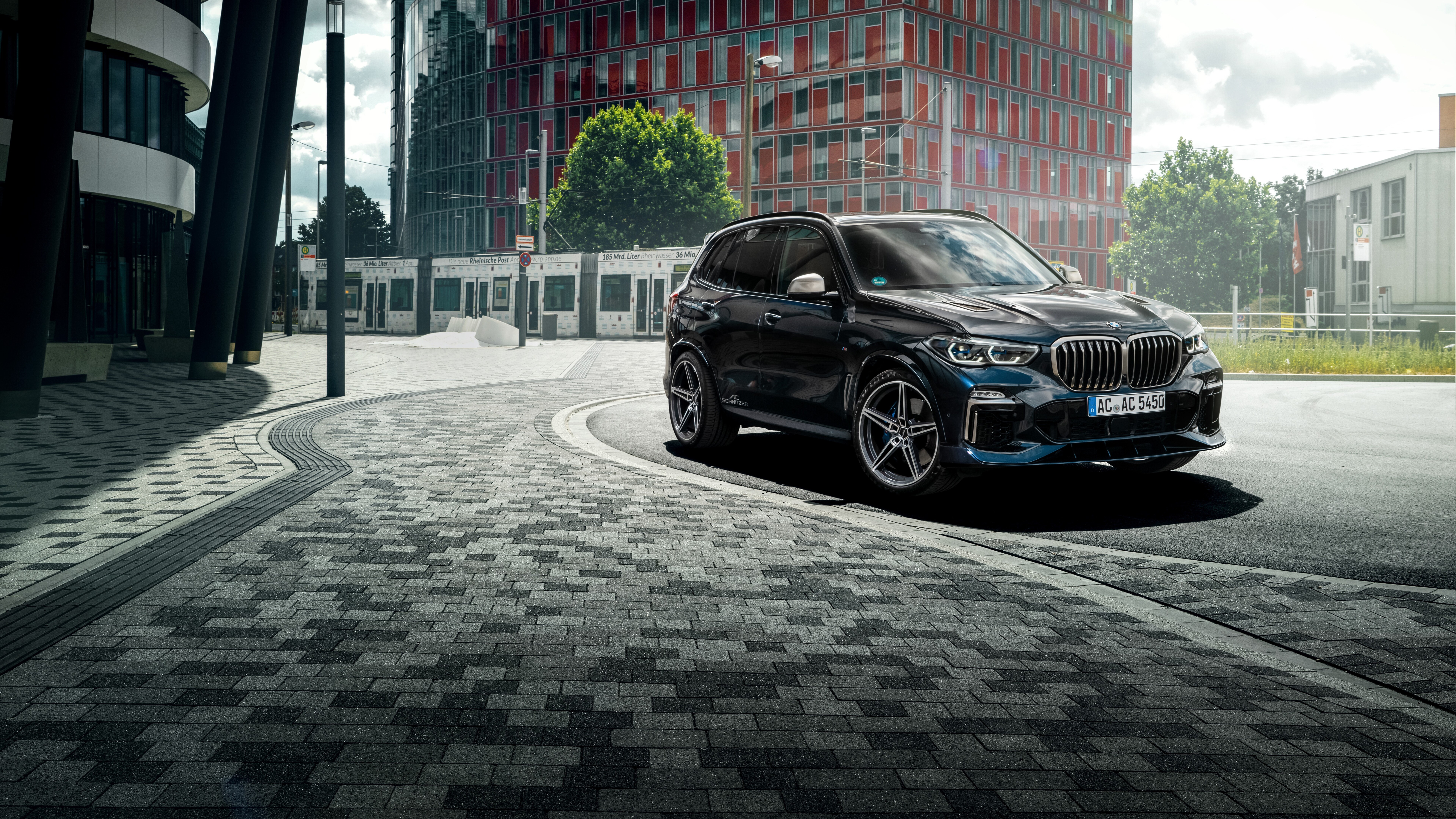 Un elegante e lucente SUV BMW X5 nero, parcheggiato in un ambiente professionale.