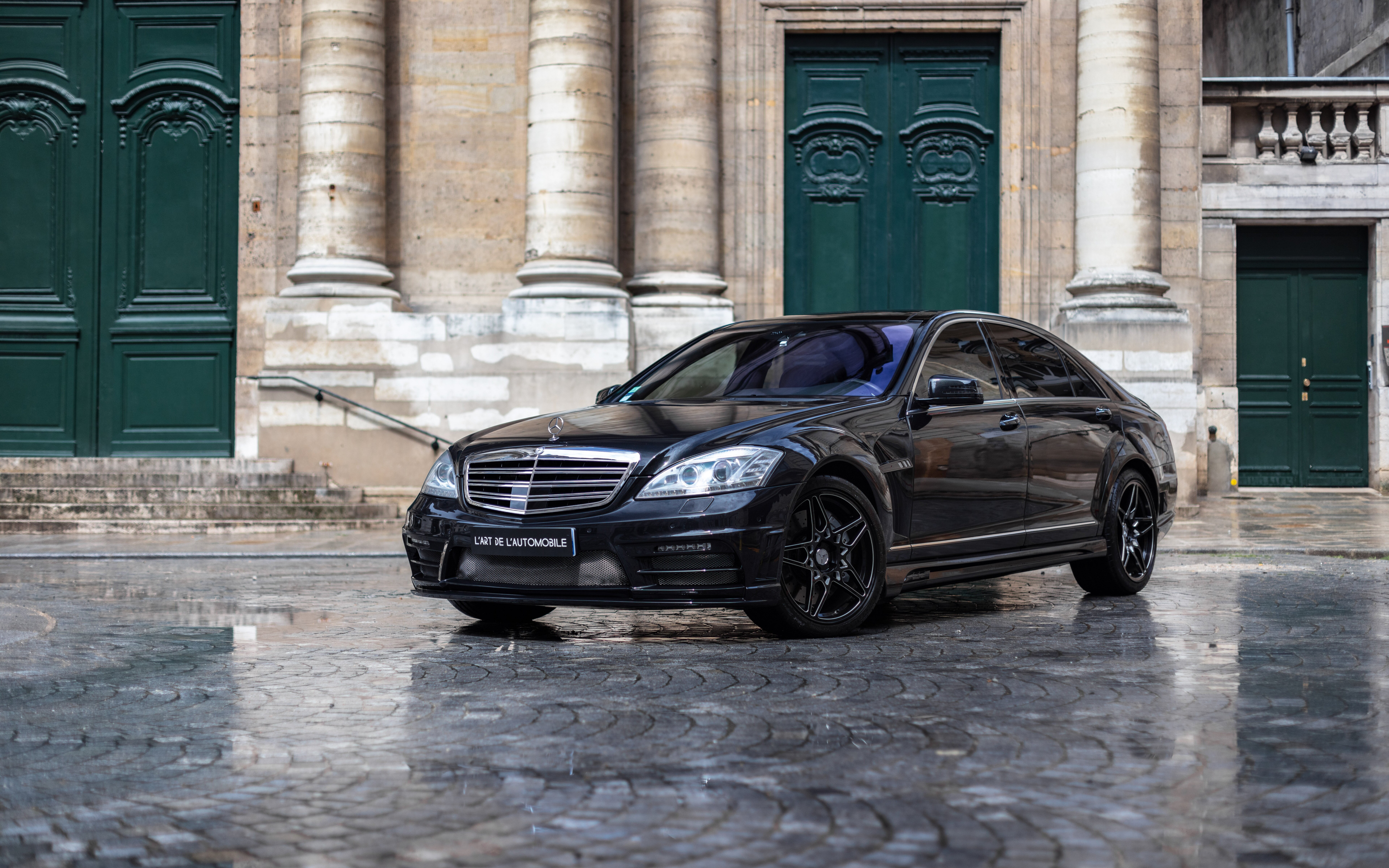 A high-gloss black Mercedes-Benz S-Class luxury sedan featuring a sleek and premium automotive design.