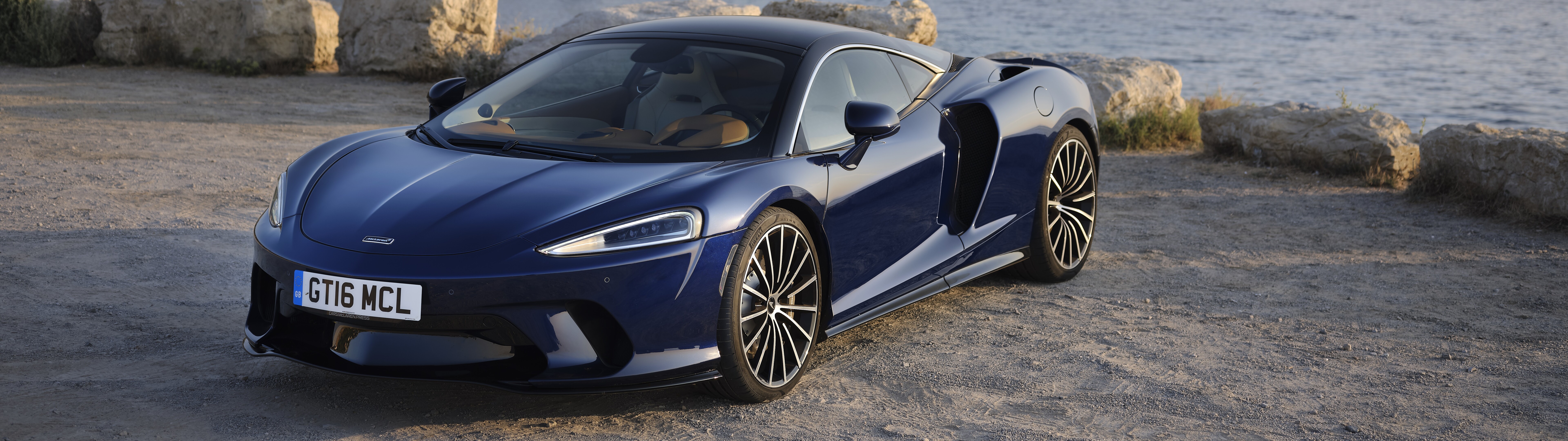 A high-resolution close-up of a sleek McLaren GT supercar highlighting its aerodynamic curves.