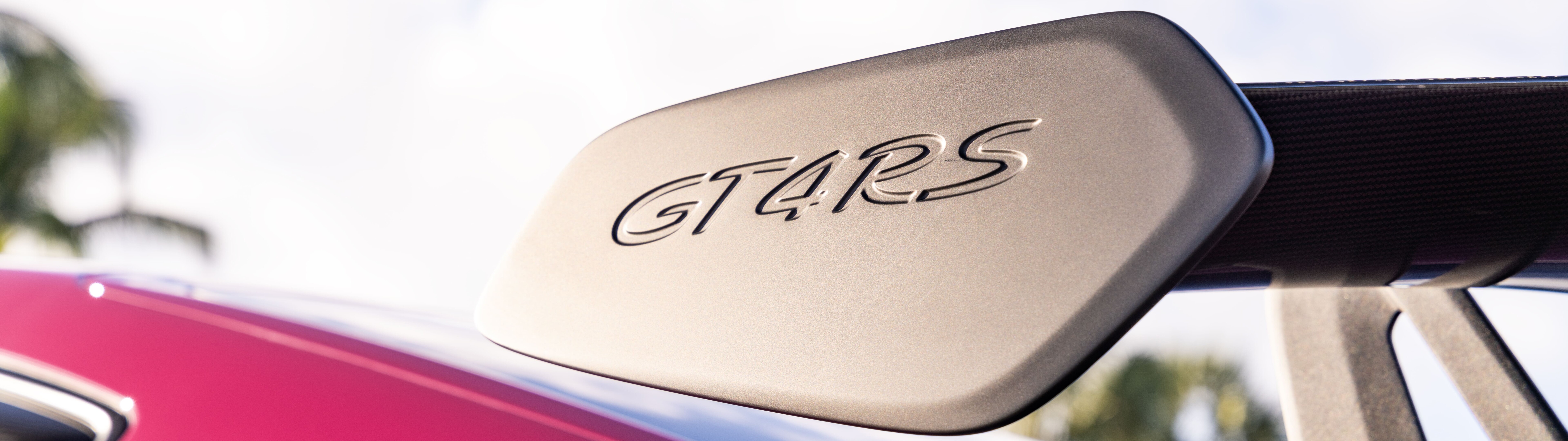 A detailed close-up of a polished Porsche sports car featuring sleek lines and reflective metallic surfaces.