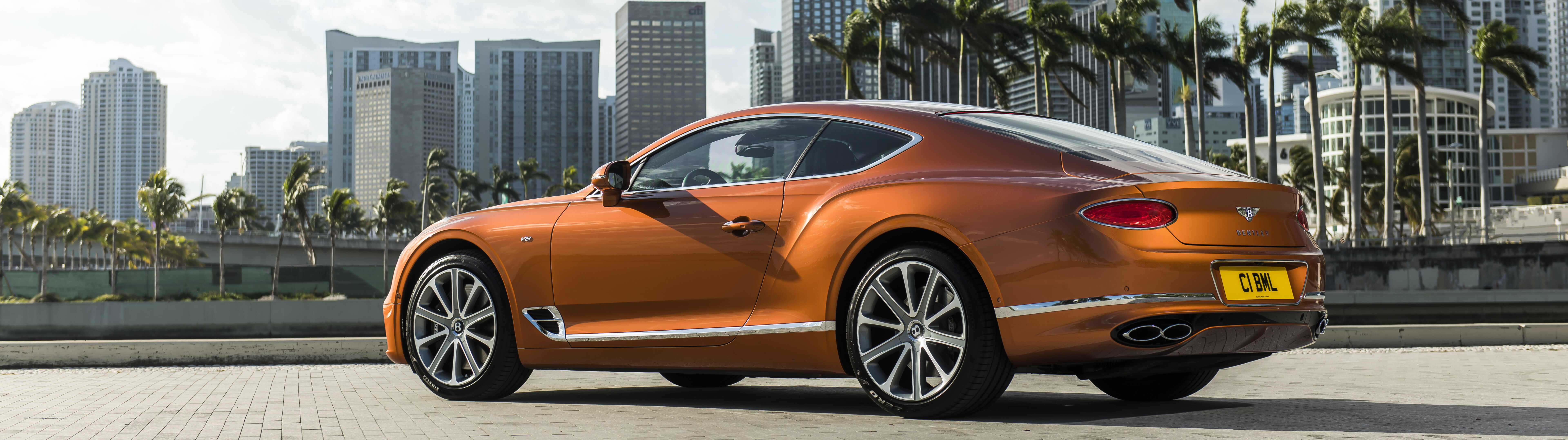 Una lussuosa Bentley Continental GT color arancione, che mette in risalto il suo design elegante e il colore vivace.
