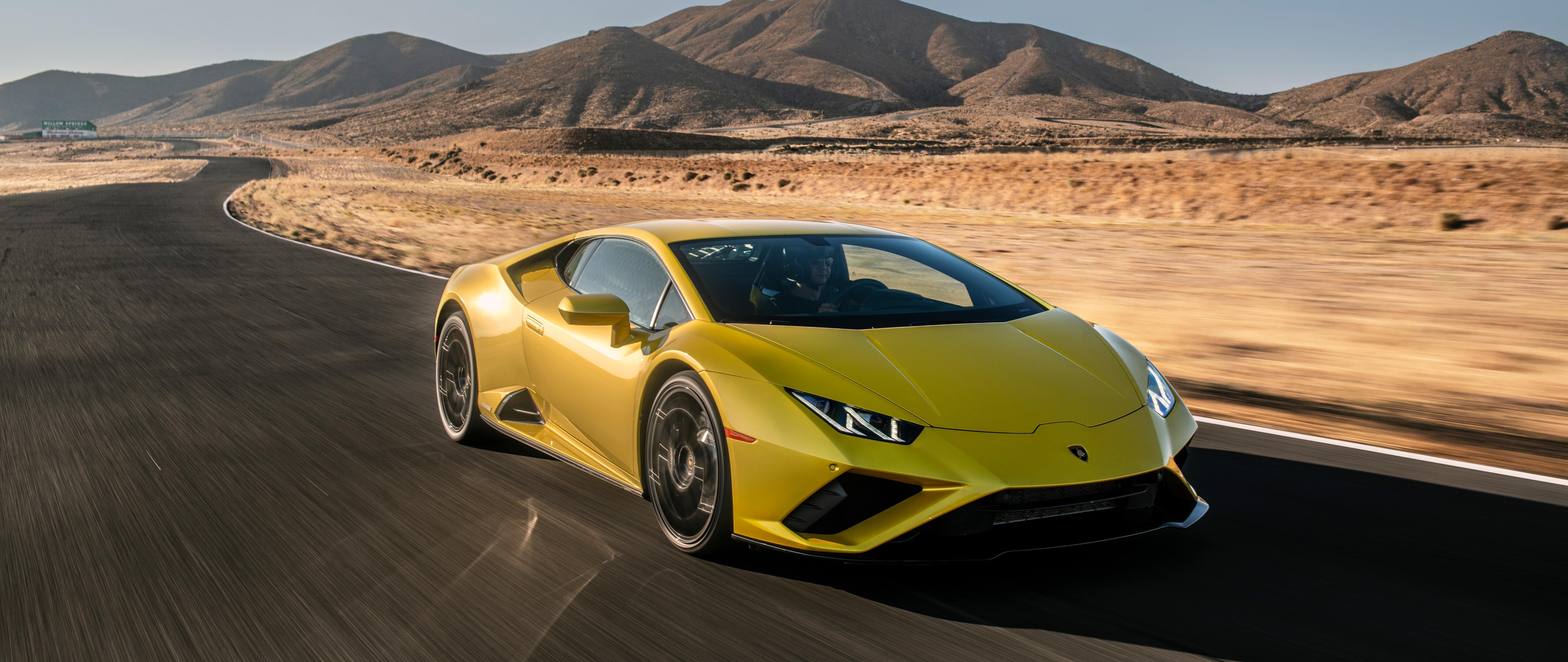 Una Lamborghini Huracán Evo, elegante e di un giallo brillante, che mette in risalto il suo design aerodinamico da supercar.