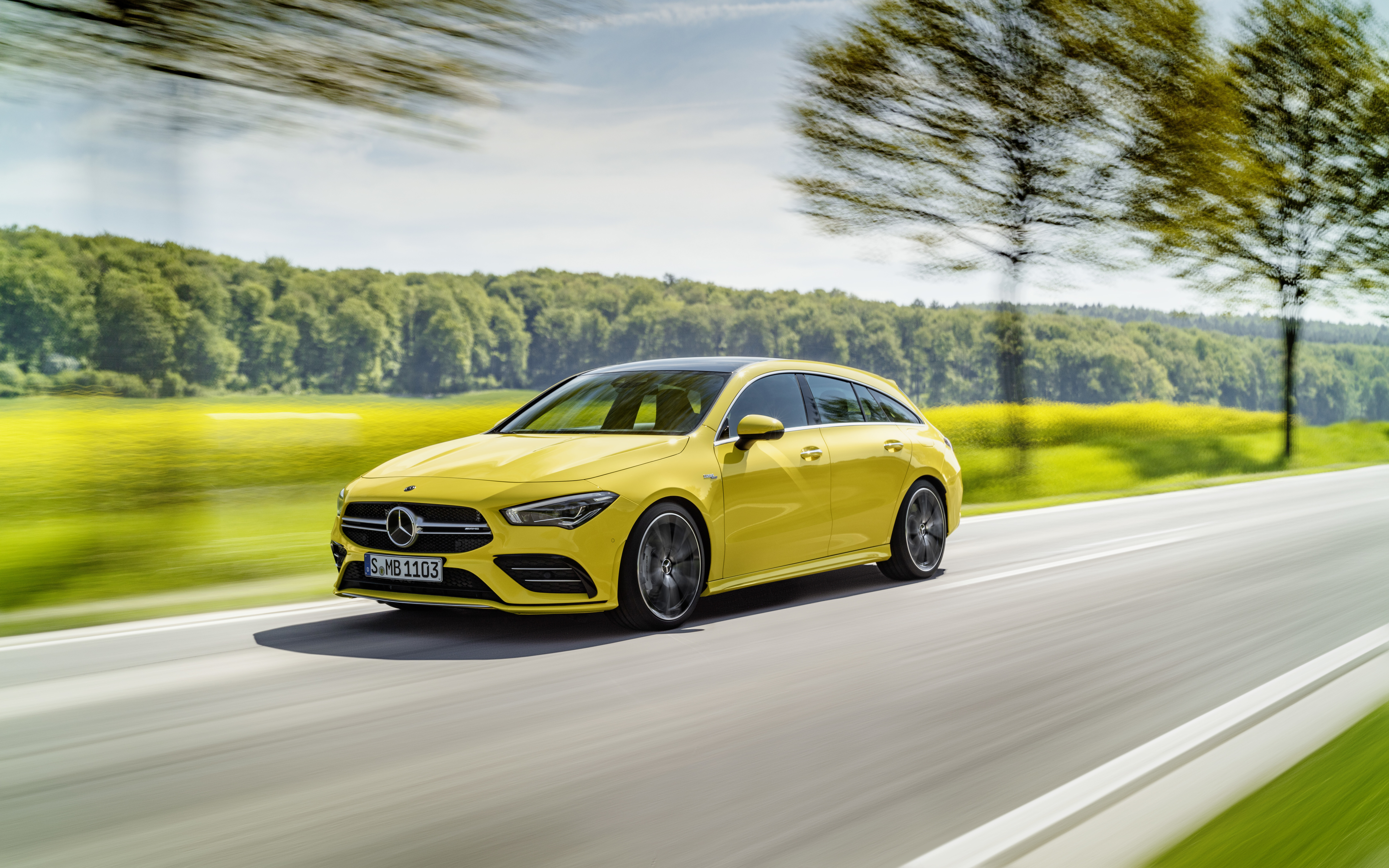 Una lussuosa berlina Mercedes-Benz CLA-Class di colore giallo brillante, che mette in risalto il suo design aerodinamico.