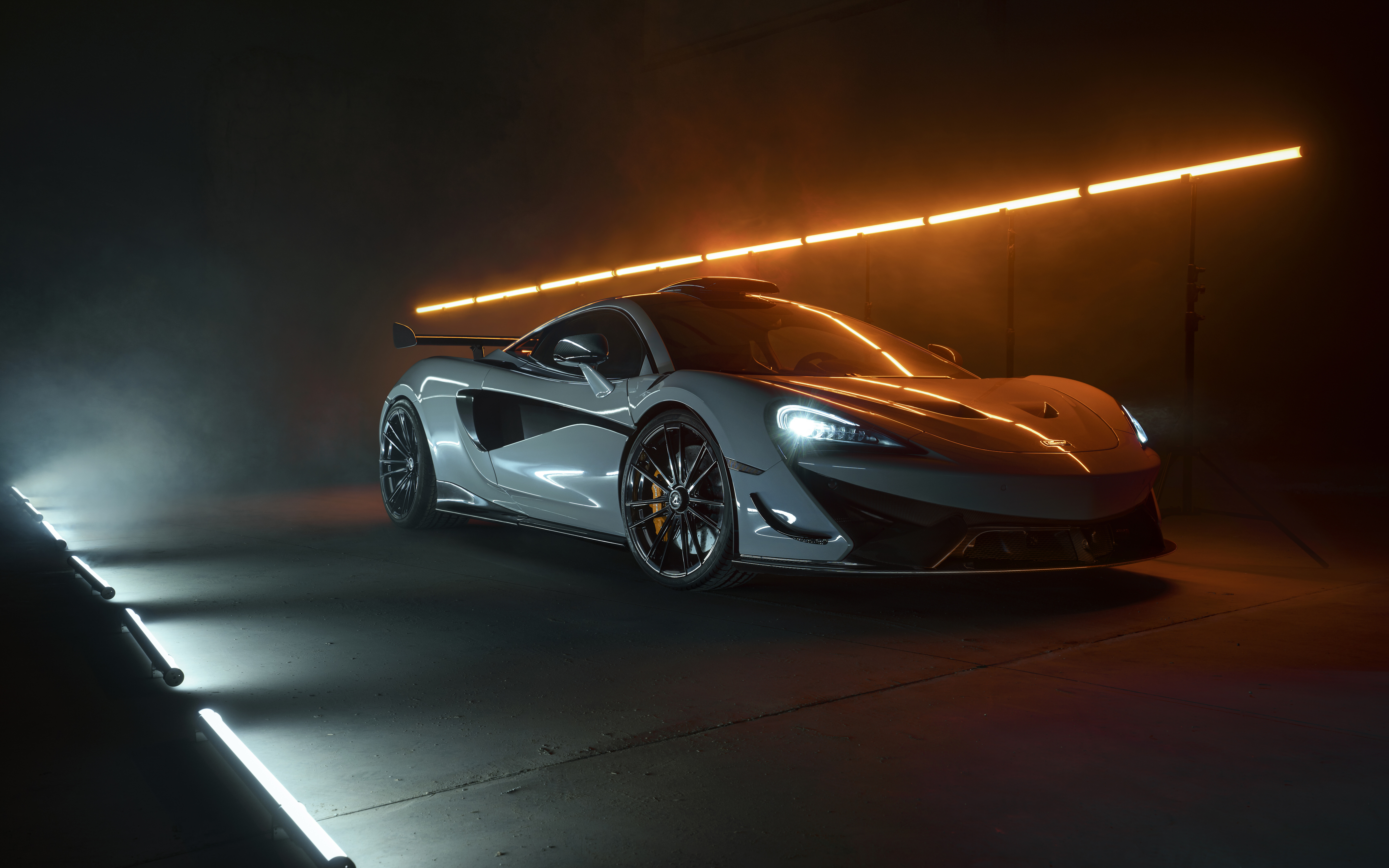Un’immagine dettagliata di una supercar bianca, una McLaren 620R, che ne mette in risalto la moderna carrozzeria aerodinamica.