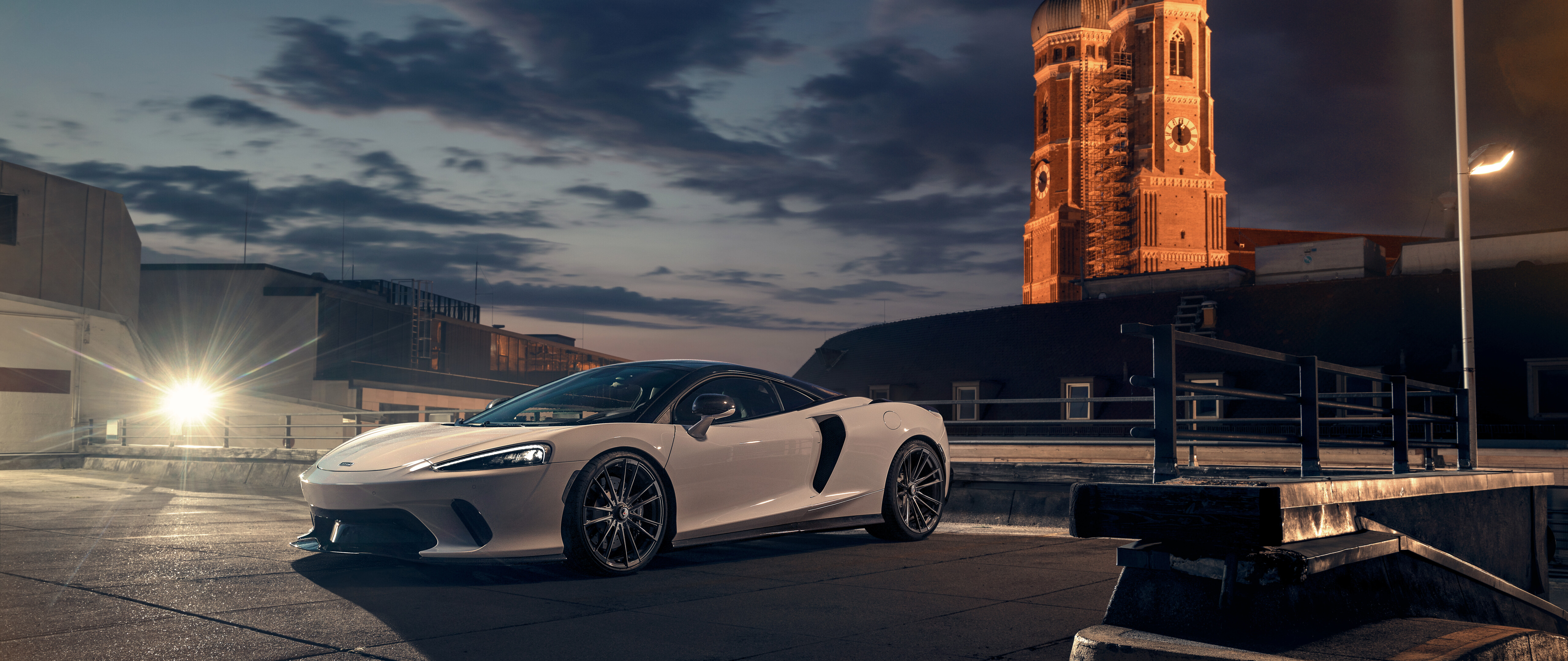 A sleek white McLaren GT supercar featuring modern aerodynamic design and luxury aesthetics.