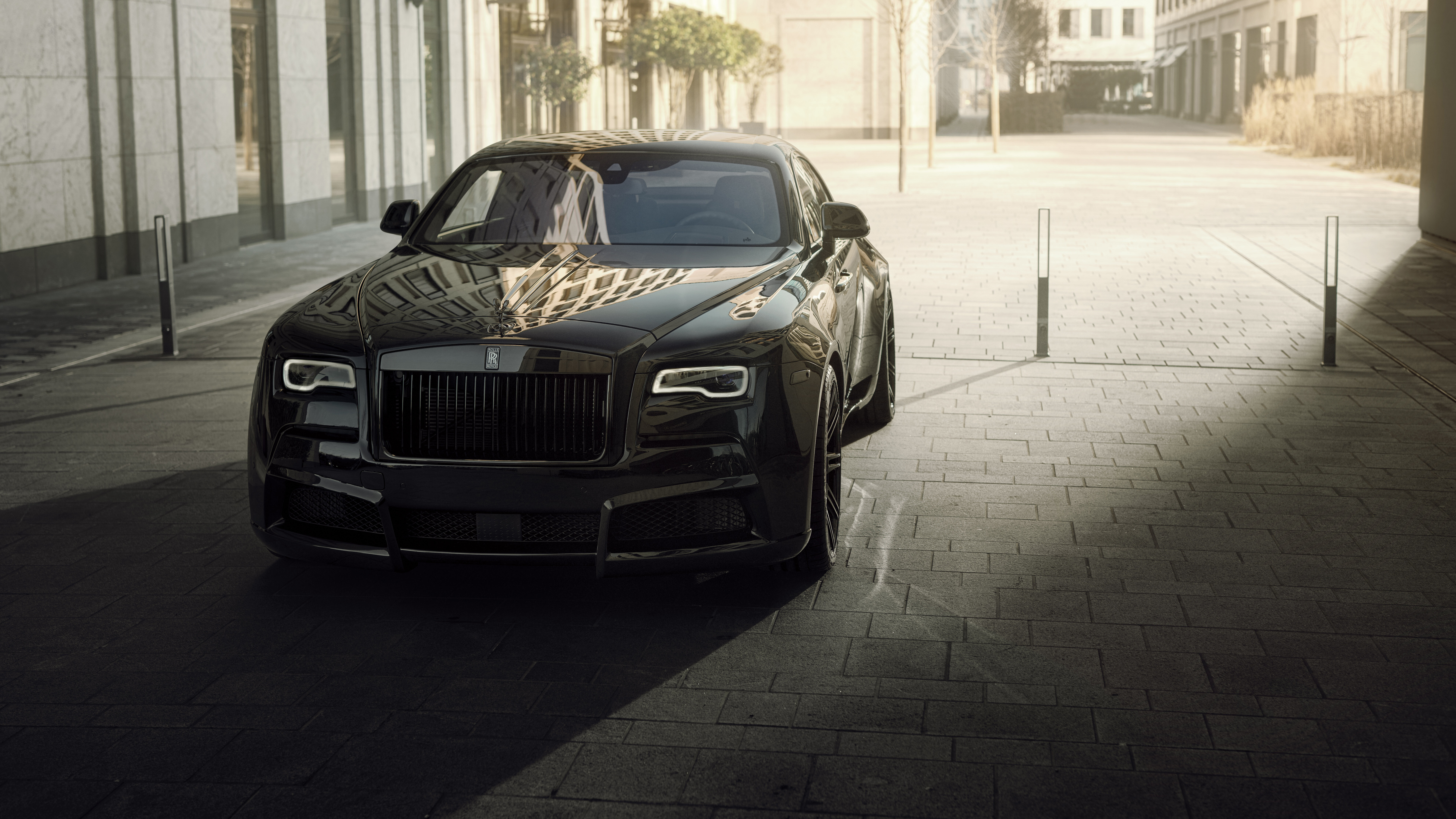 A premium black Rolls-Royce Wraith luxury vehicle featuring a deep glossy finish.