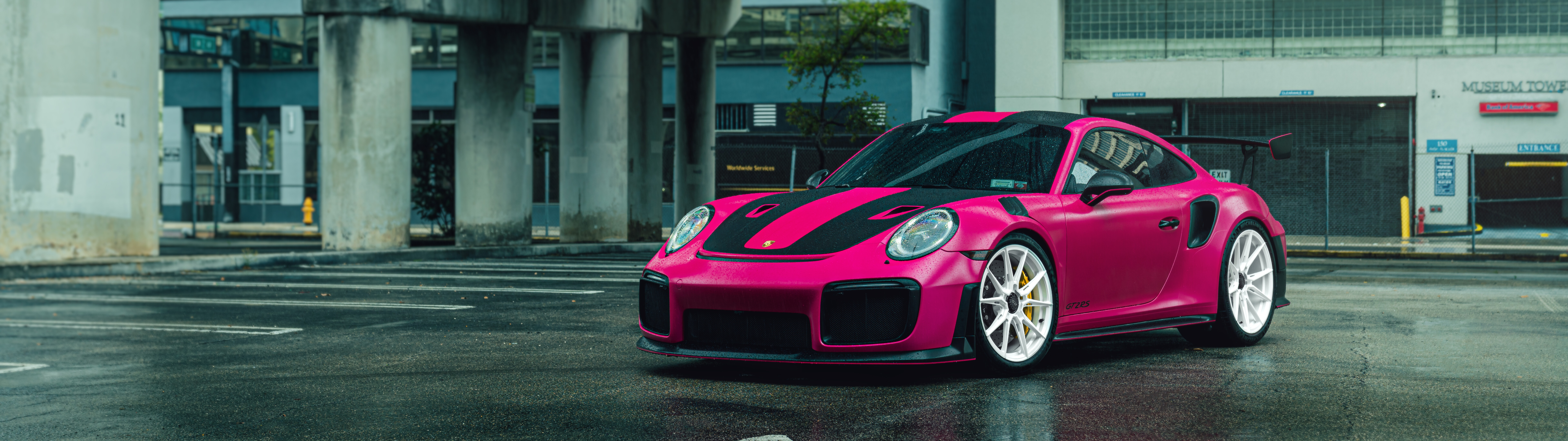 Una lussuosa auto sportiva Porsche 911 GT2 RS di colore rosa acceso.