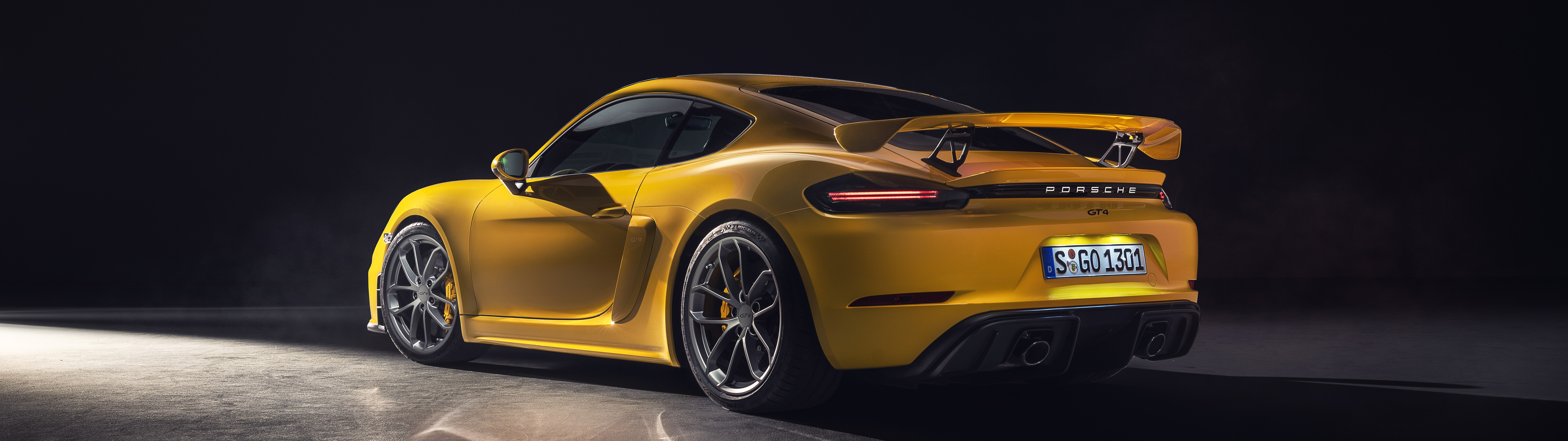 A vibrant yellow Porsche 718 Cayman sports car.
