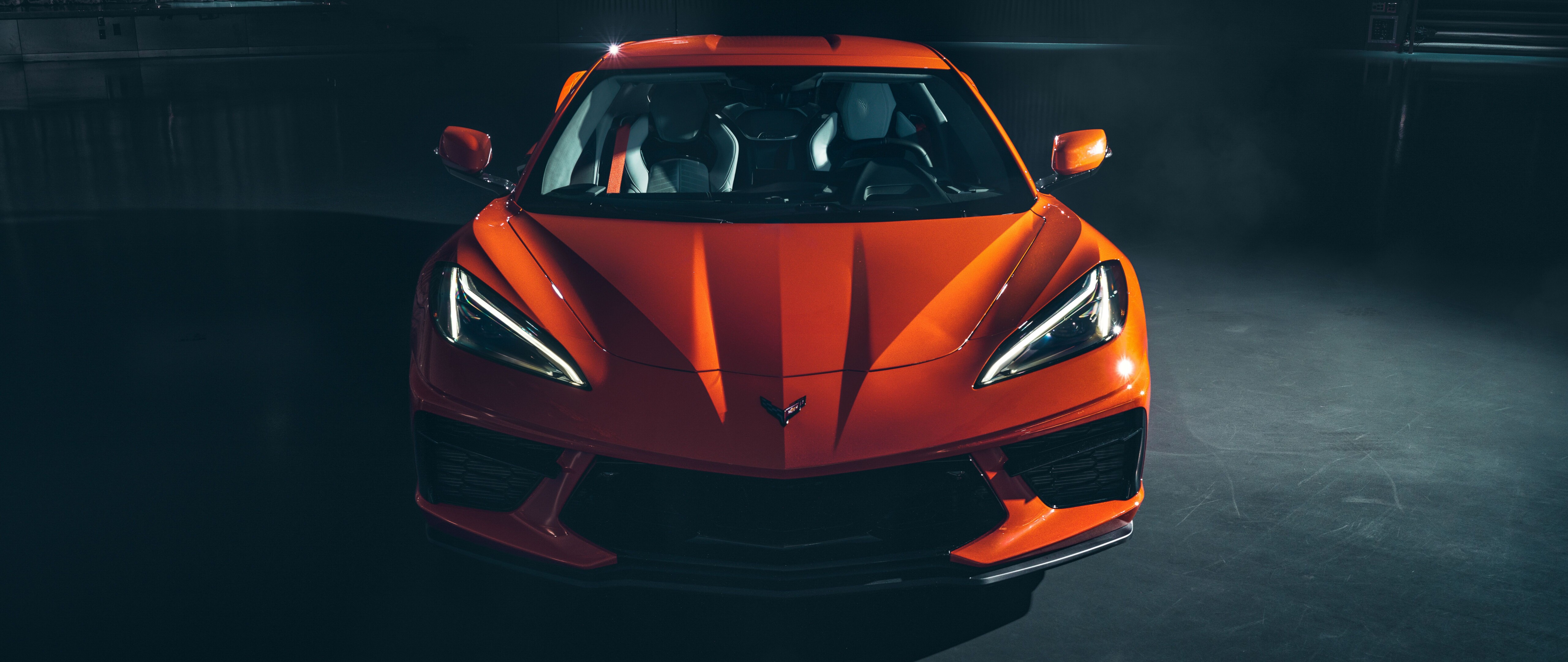 A bright orange Chevrolet Corvette C8 sports car highlighting its sleek aerodynamic design.