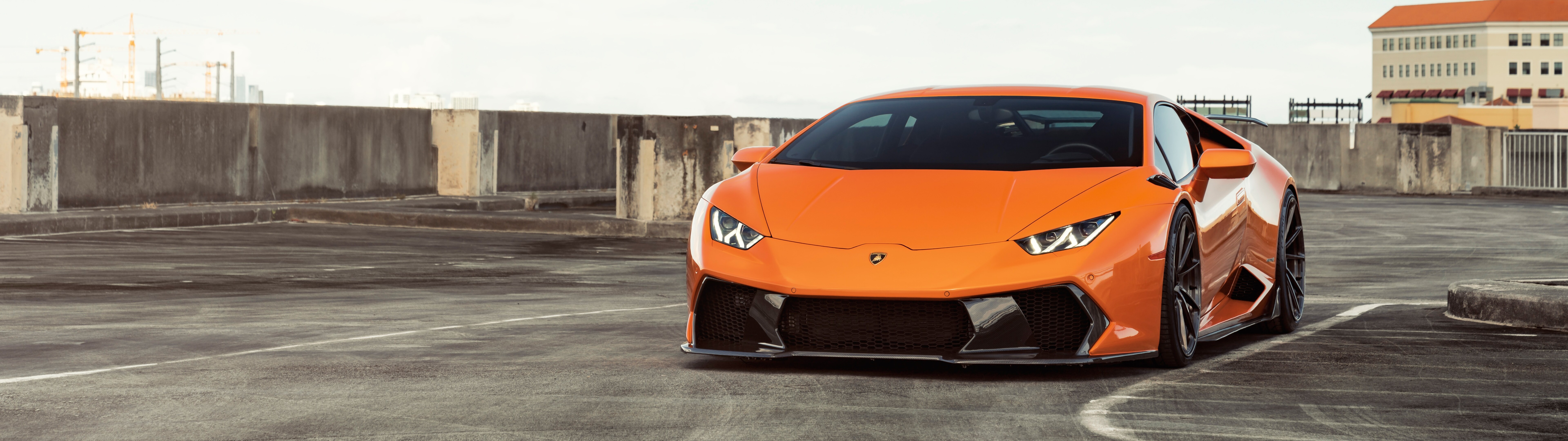 A sleek and polished bright orange Lamborghini Huracan supercar showcasing its aerodynamic design.