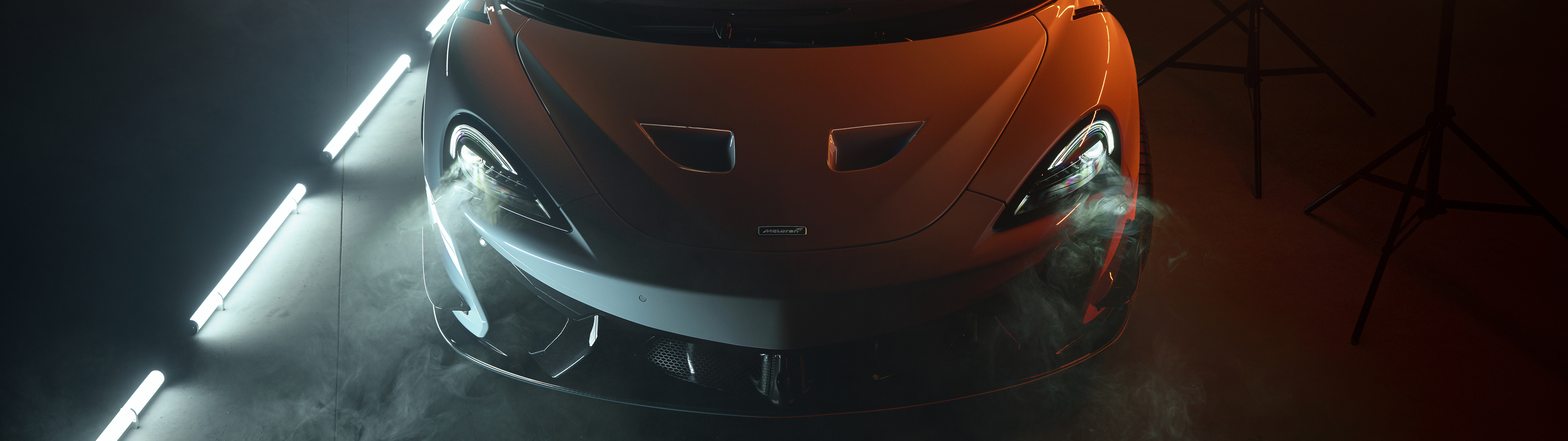 A high-performance McLaren 620R supercar in a bright orange finish, showcasing its aerodynamic design.