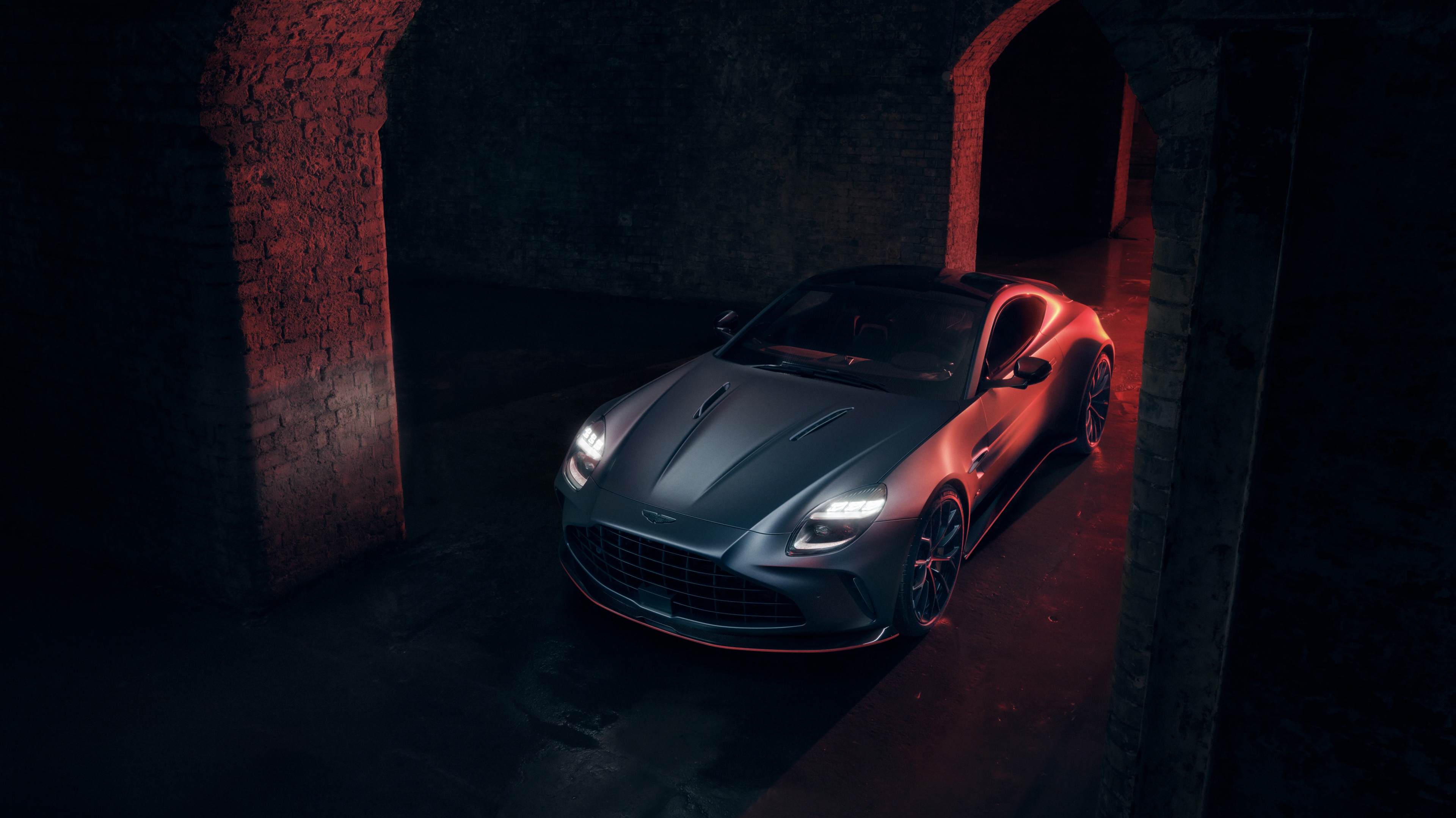 A sleek 2025 Aston Martin Vantage S featured in a dark, cinematic atmosphere with high-contrast lighting.
