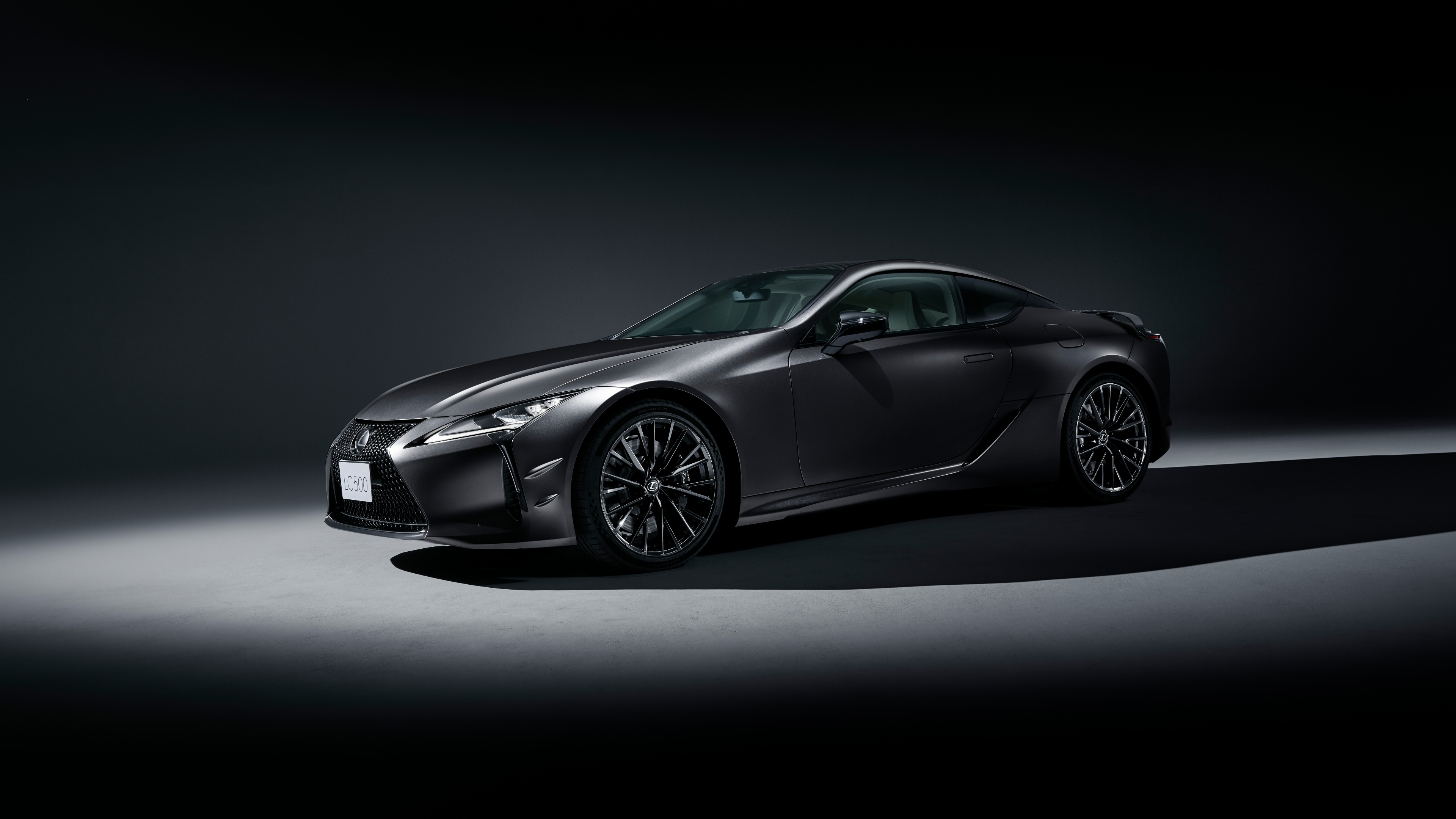 A high-resolution, close-up shot of a modern 2025 luxury coupe with a sleek design against a dark, moody background.