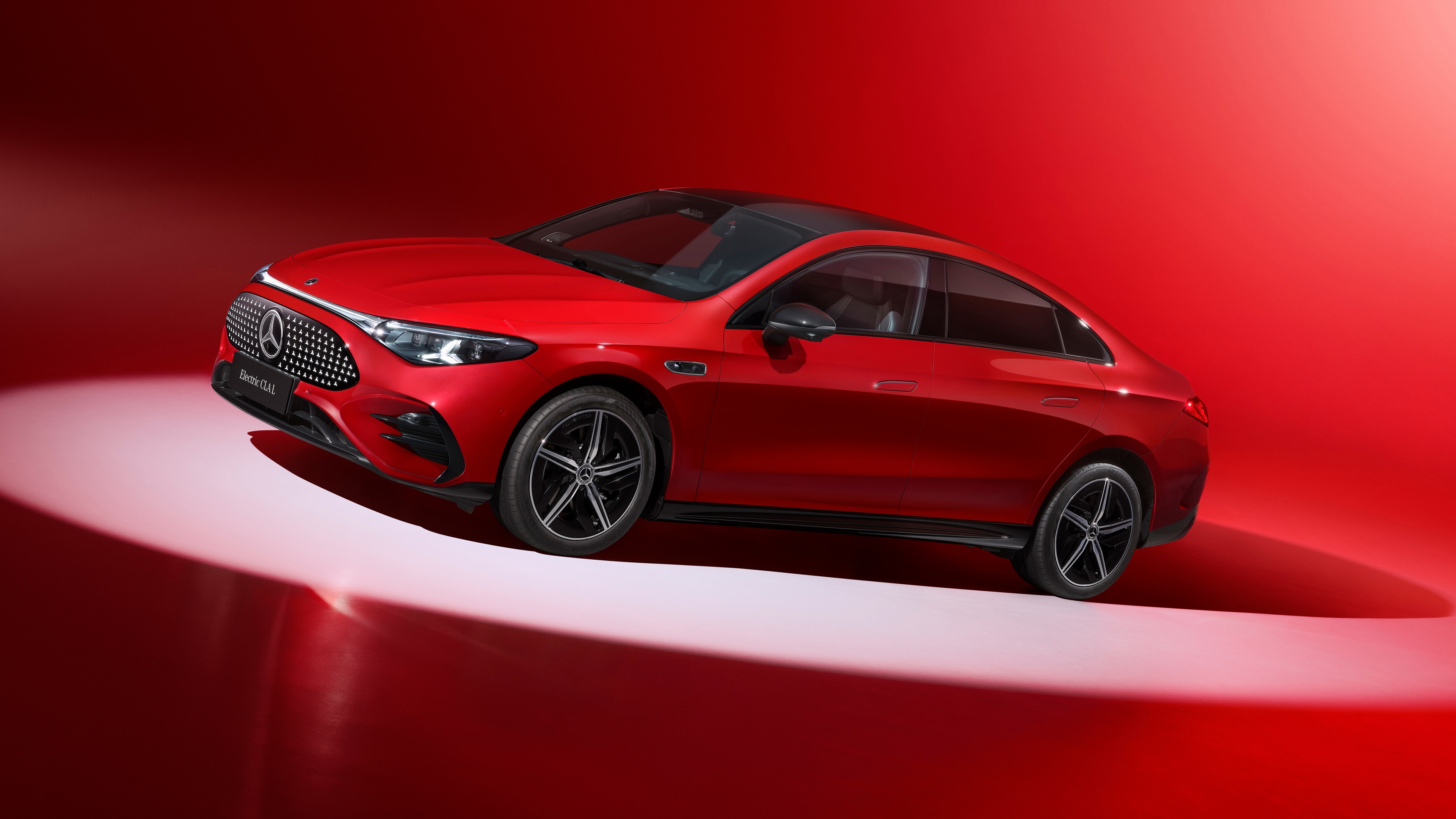 A high-resolution shot of a red 2025 Mercedes-Benz CLA 300 L against a vibrant red background.