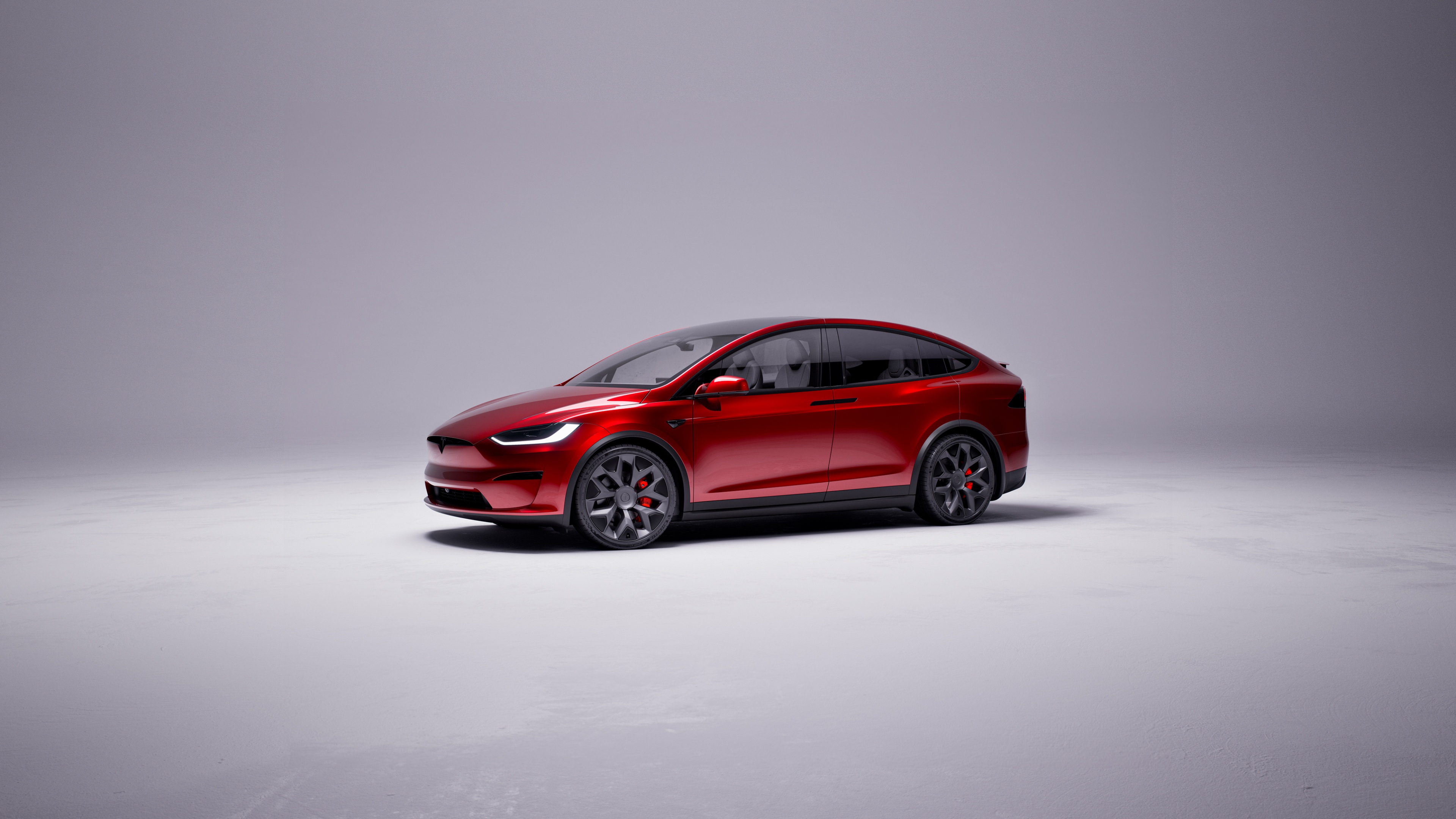 A high-performance 2025 Tesla Model X Plaid electric SUV in a striking red finish.