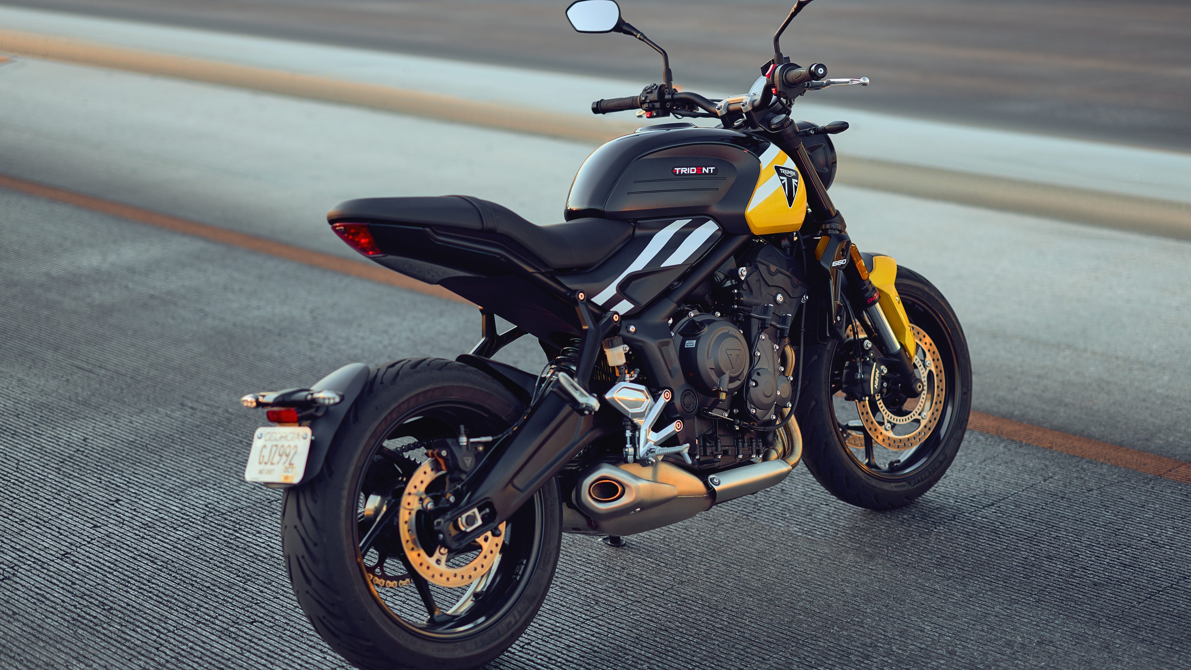 A detailed, high-resolution close-up of the 2025 Triumph Trident 660 naked motorcycle showing its aggressive design and metallic components.