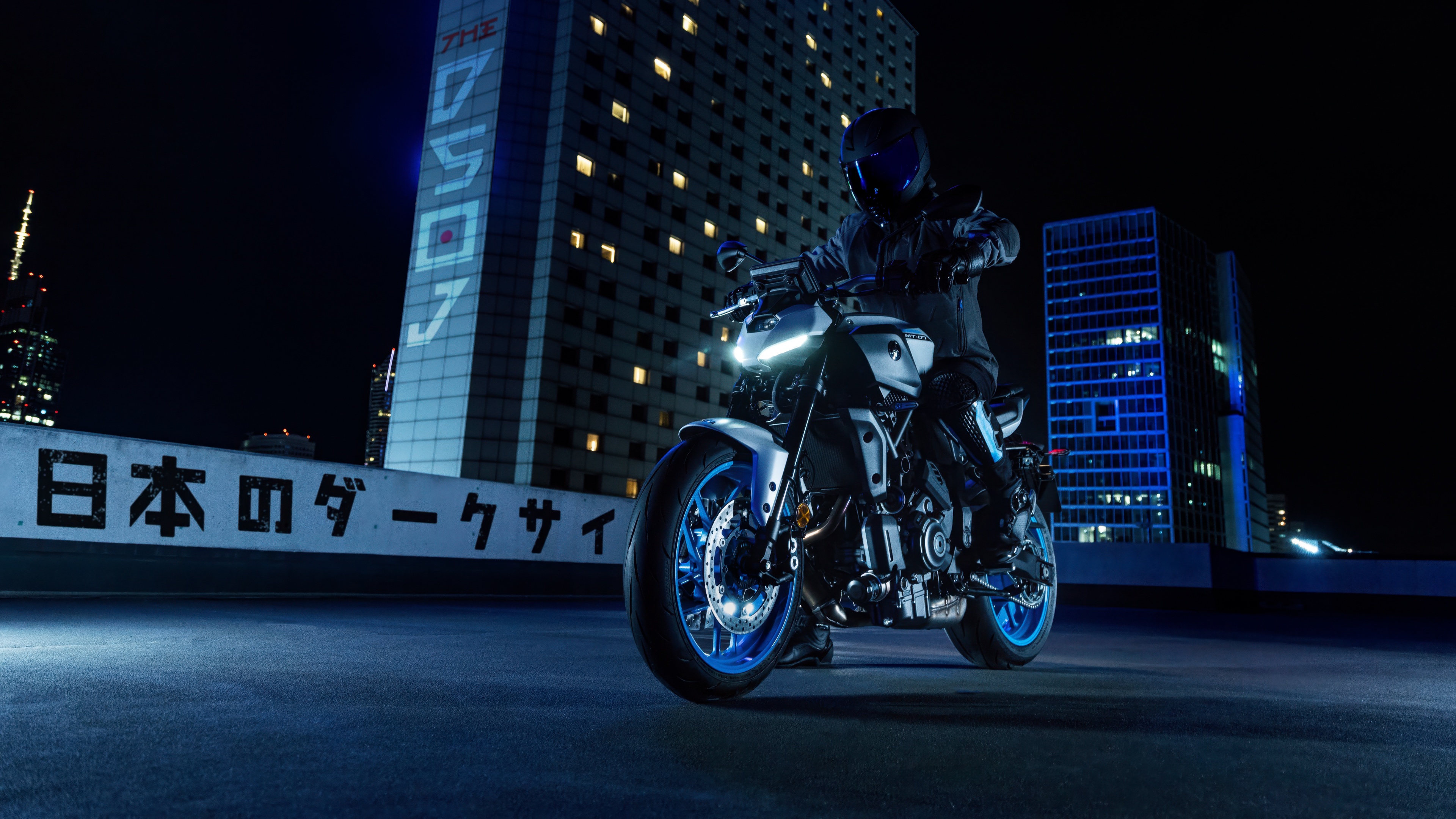 A sleek 2025 Yamaha MT-07 naked motorcycle parked on a city street under night lights.