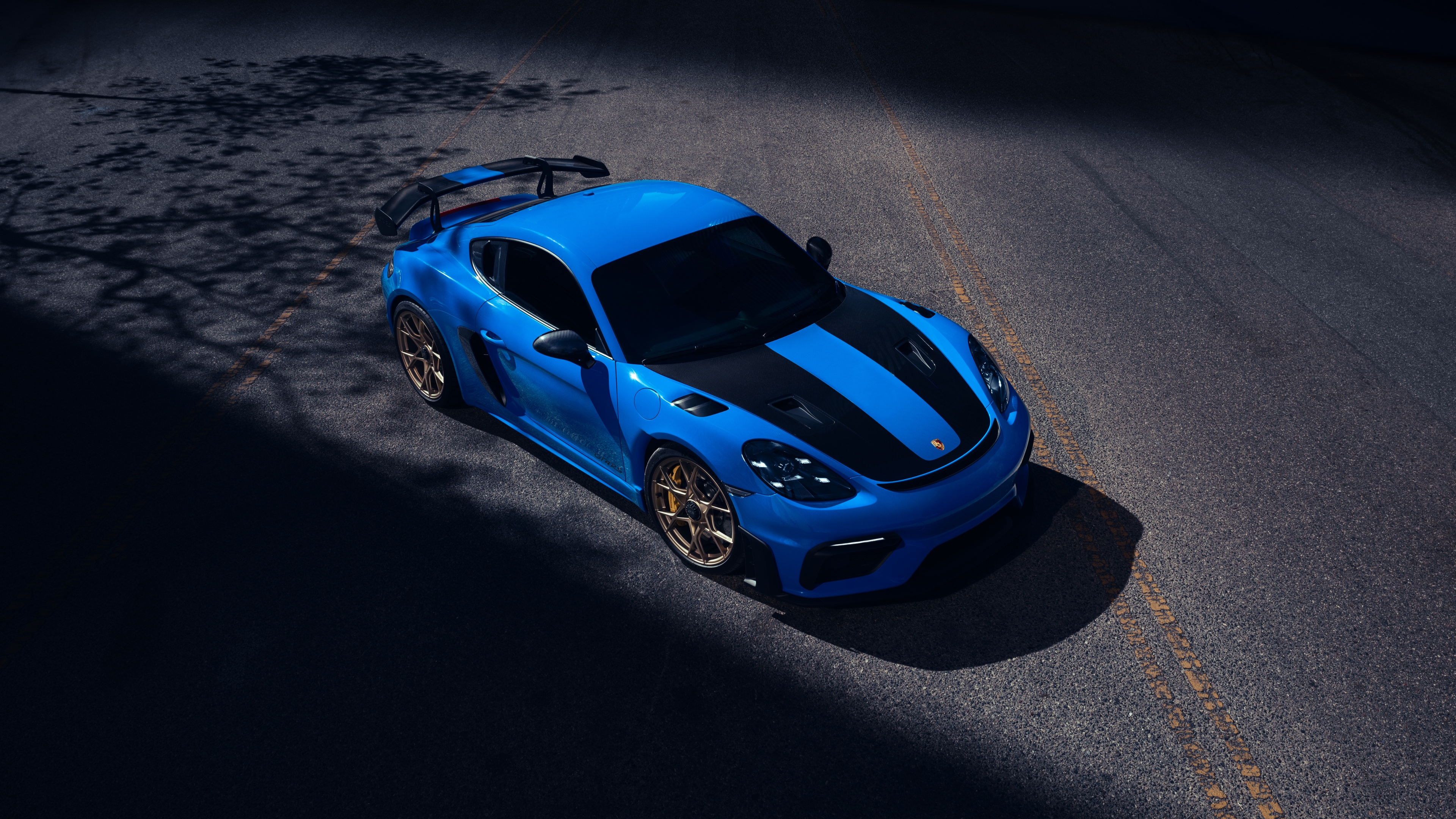 Close-up of a blue Porsche 718 Cayman GT4 RS featuring racing stripes