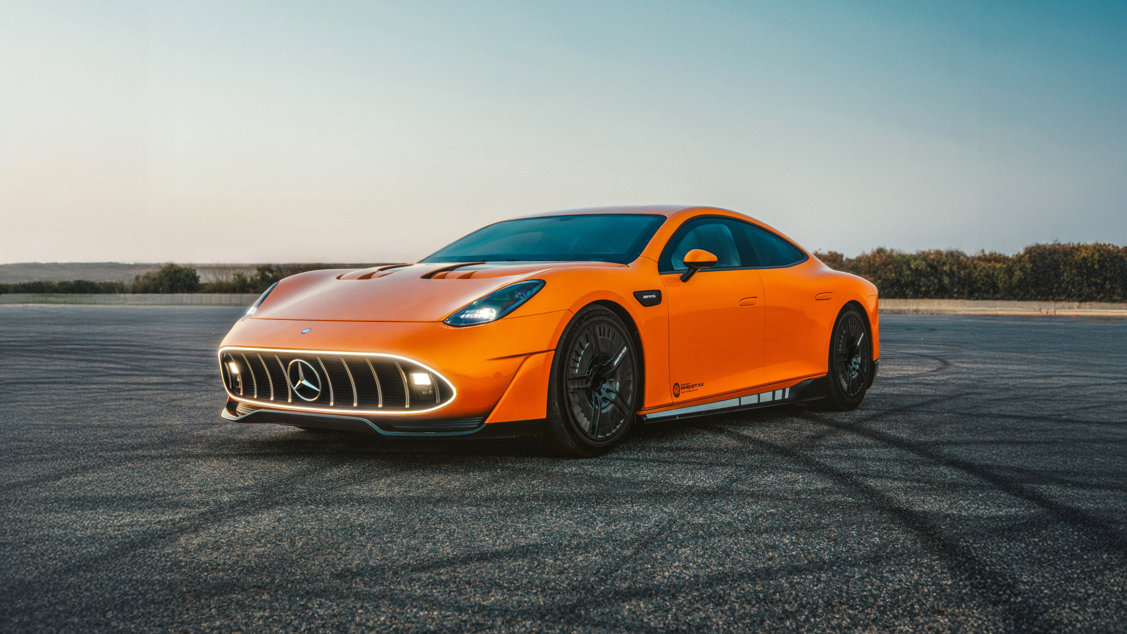 A sleek and aerodynamic 2025 Concept AMG GT XX luxury sports car positioned in an outdoor setting.