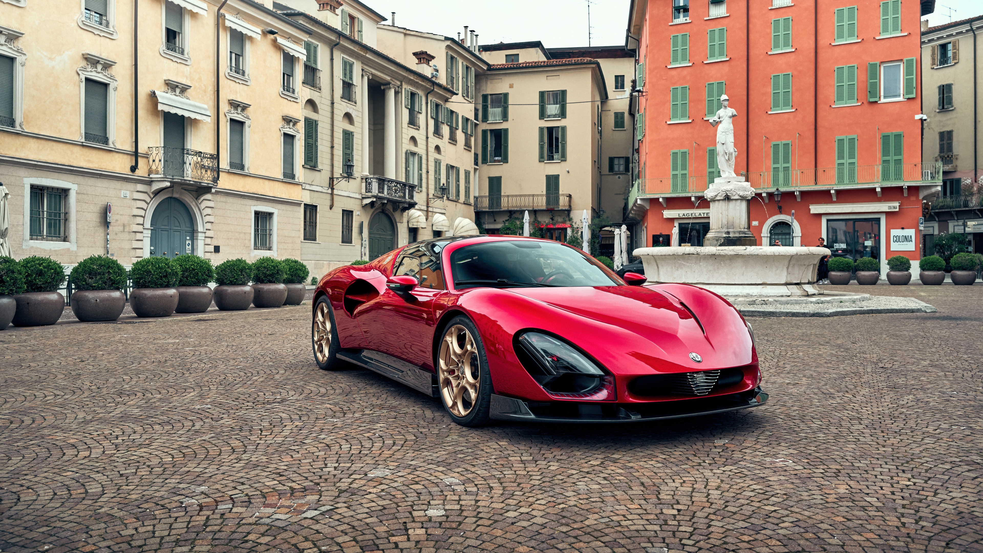 A vibrant red Alfa Romeo 33 Stradale supercar parked on a scenic street in Rome, Italy.