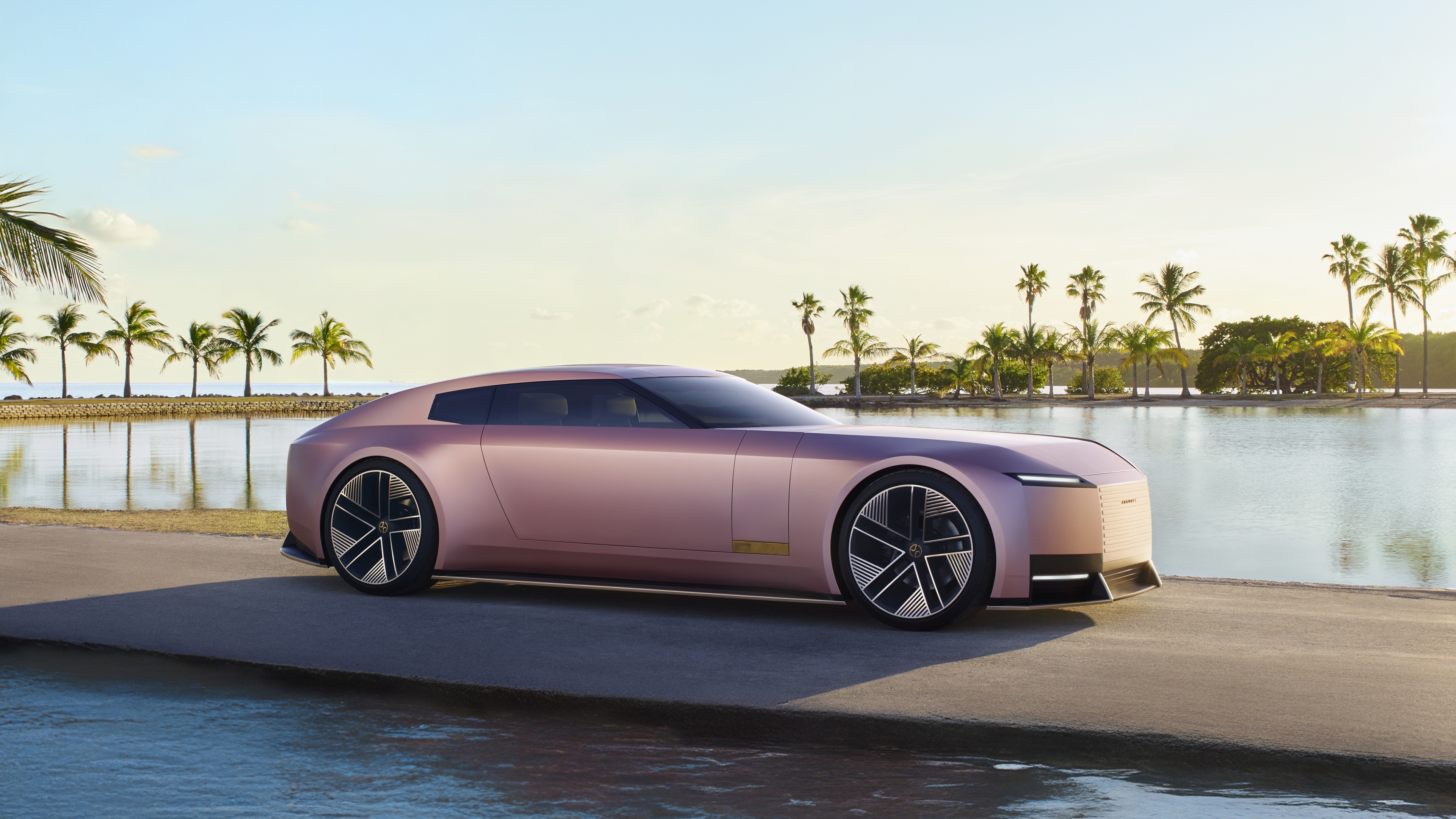 A sleek Jaguar Type 00 electric concept car parked on a sunlit Miami street, showcasing futuristic luxury design.